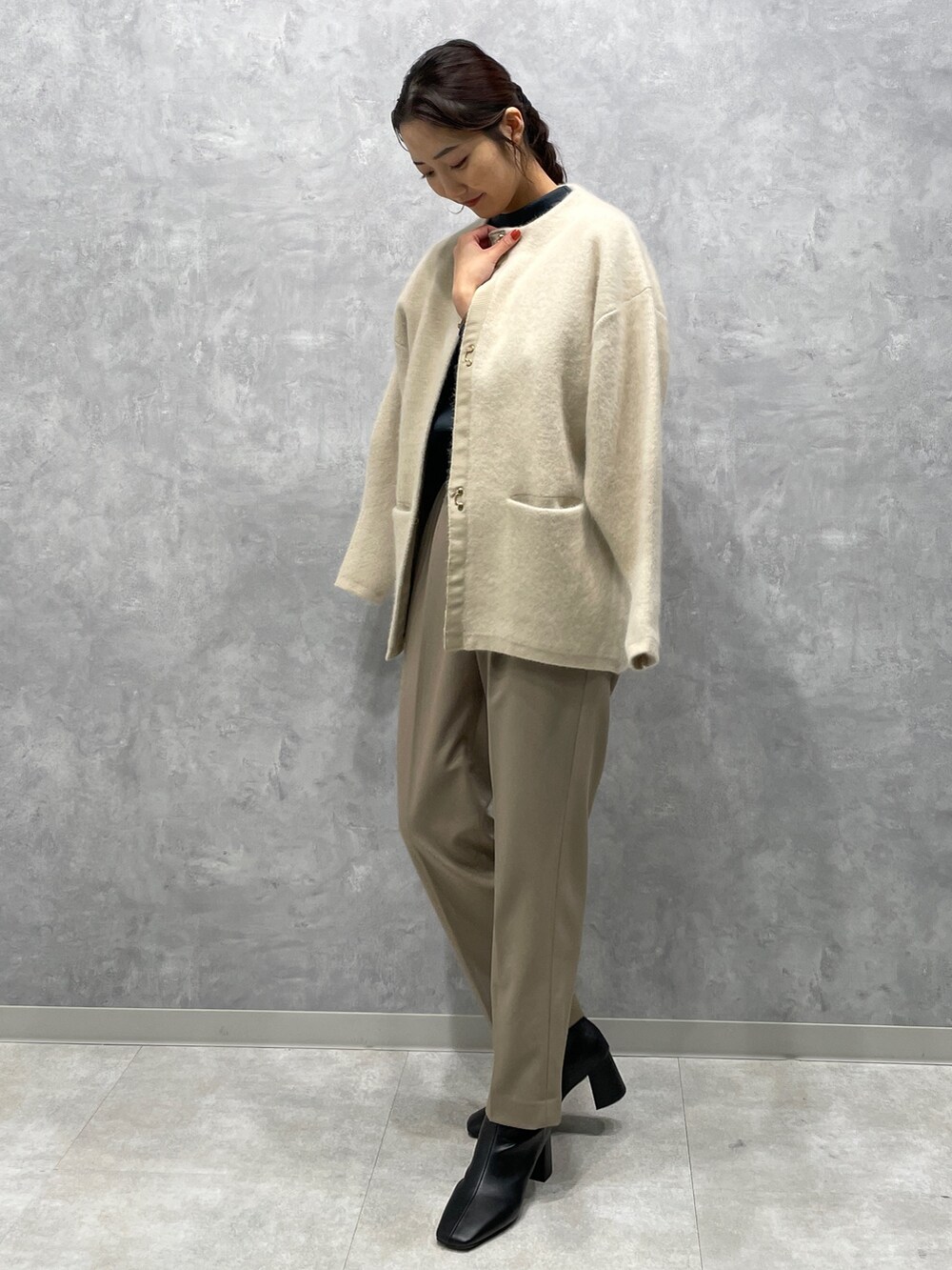 ブラック系のブーツ、ベージュ系のその他パンツ、ホワイト系のカーディガン/ボレロを着用したレディースの冬コーディネートの2枚目の写真