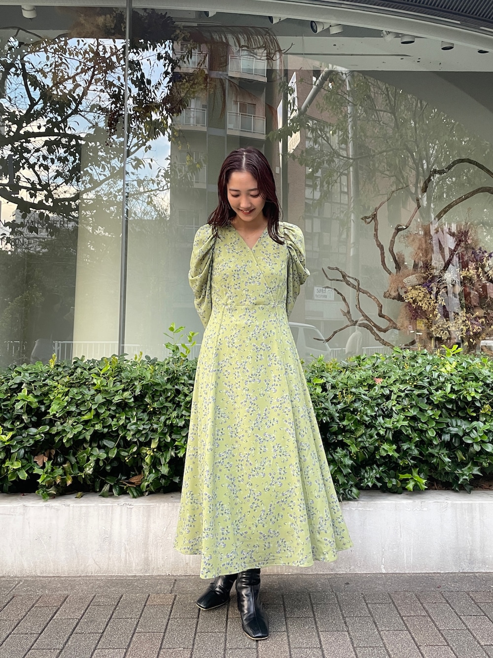 ブラック系のブーツ、グリーン系のワンピースを着用したレディースの秋コーディネートの2枚目の写真