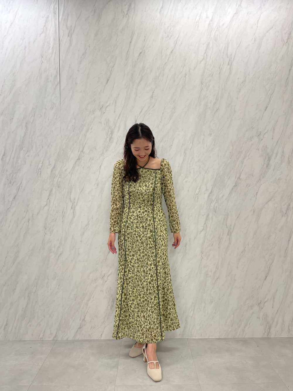 ホワイト系のパンプス、グリーン系のワンピースを着用したレディースの冬コーディネートの5枚目の写真