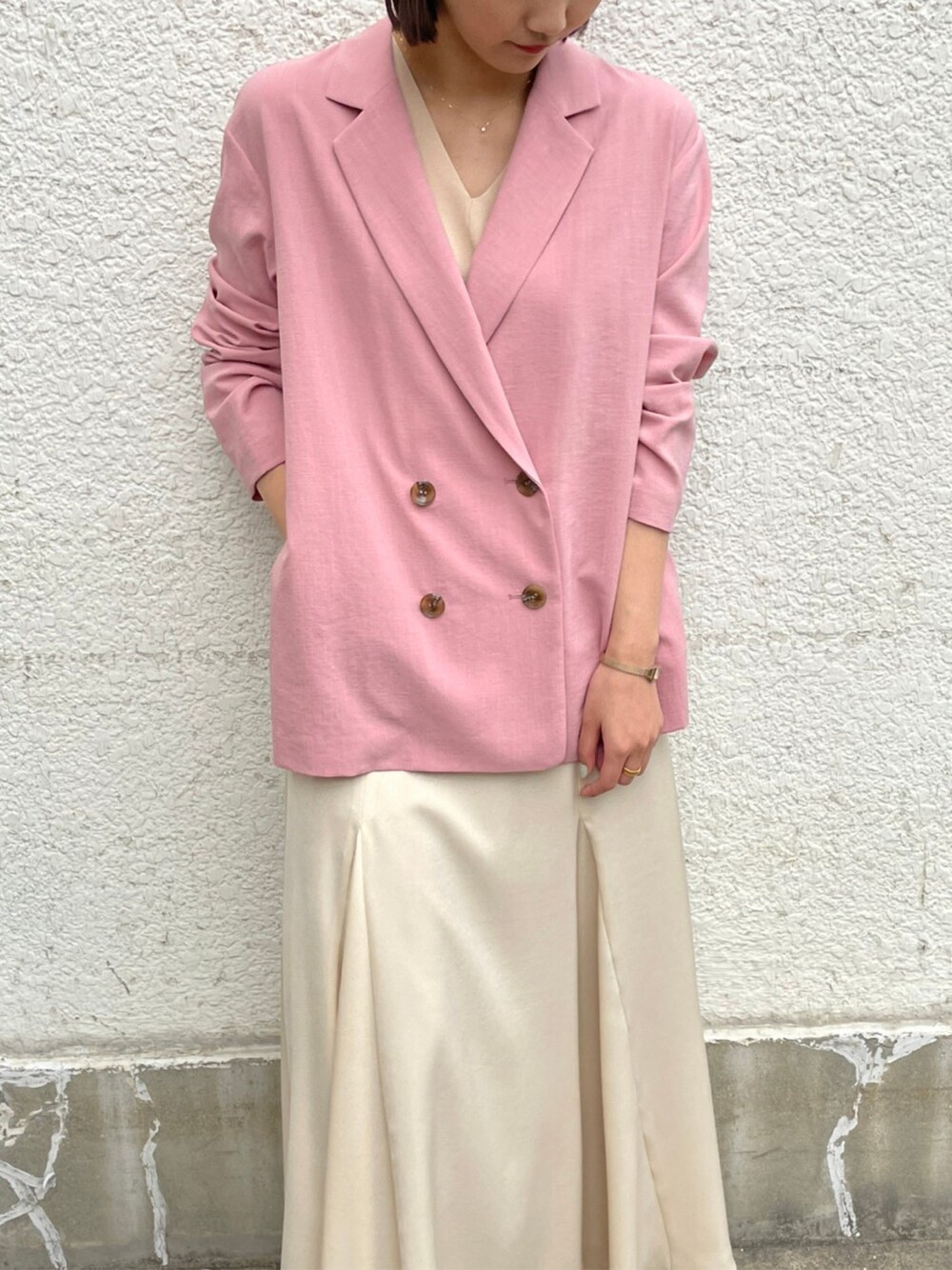 ホワイト系のスカート、ベージュ系のブーツ、ピンク系のテーラードジャケットを着用したレディースの春コーディネートの8枚目の写真