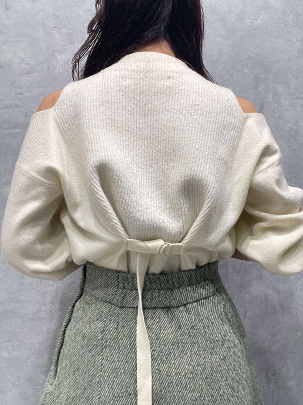 ベージュ系のブーツ、ホワイト系のニット/セーター、グリーン系のスカートを着用したレディースの冬コーディネートの9枚目の写真