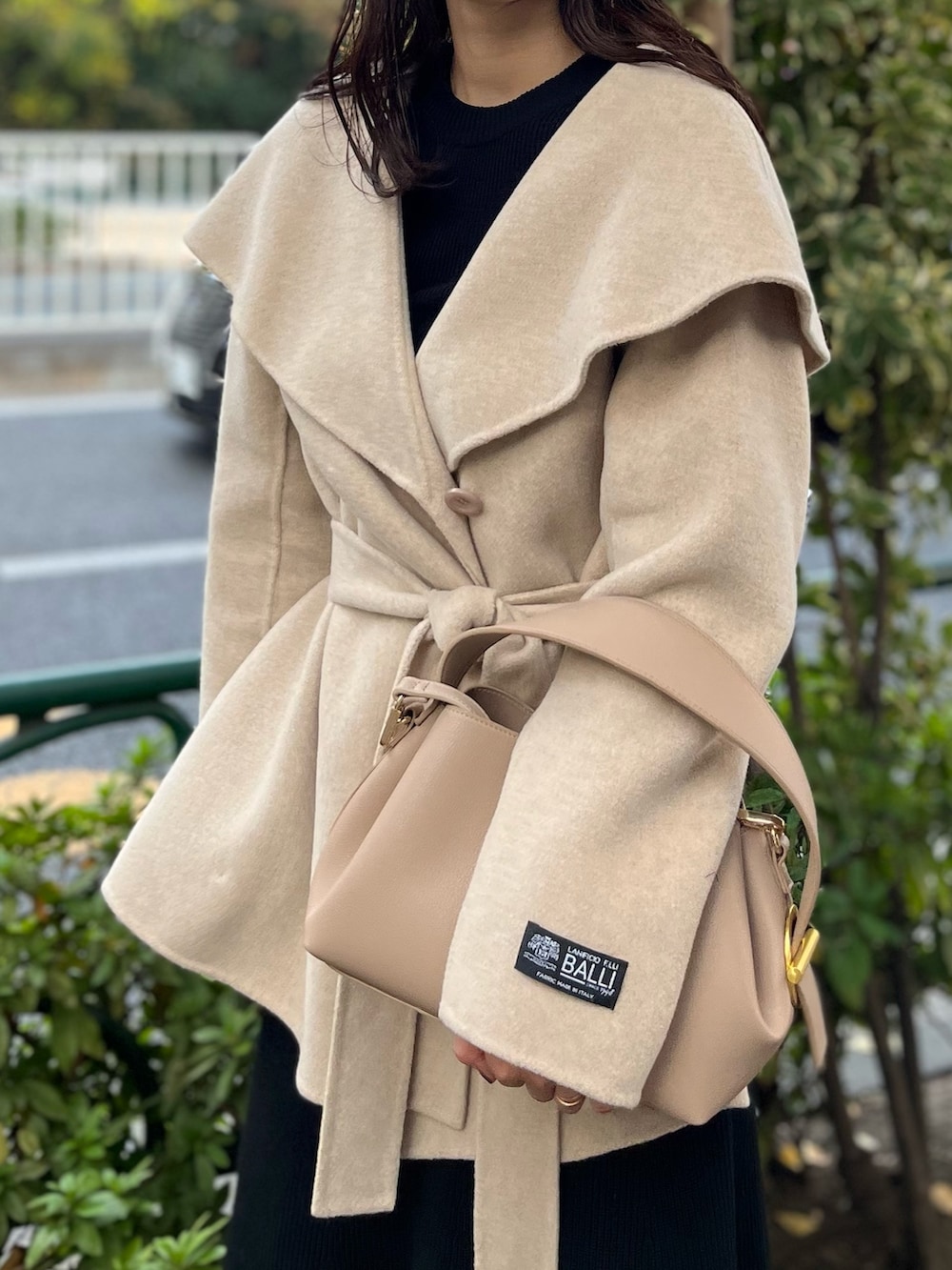 ブラック系のスカート、ブラック系のニット/セーター、グリーン系のブーツを着用したレディースの秋コーディネートの6枚目の写真