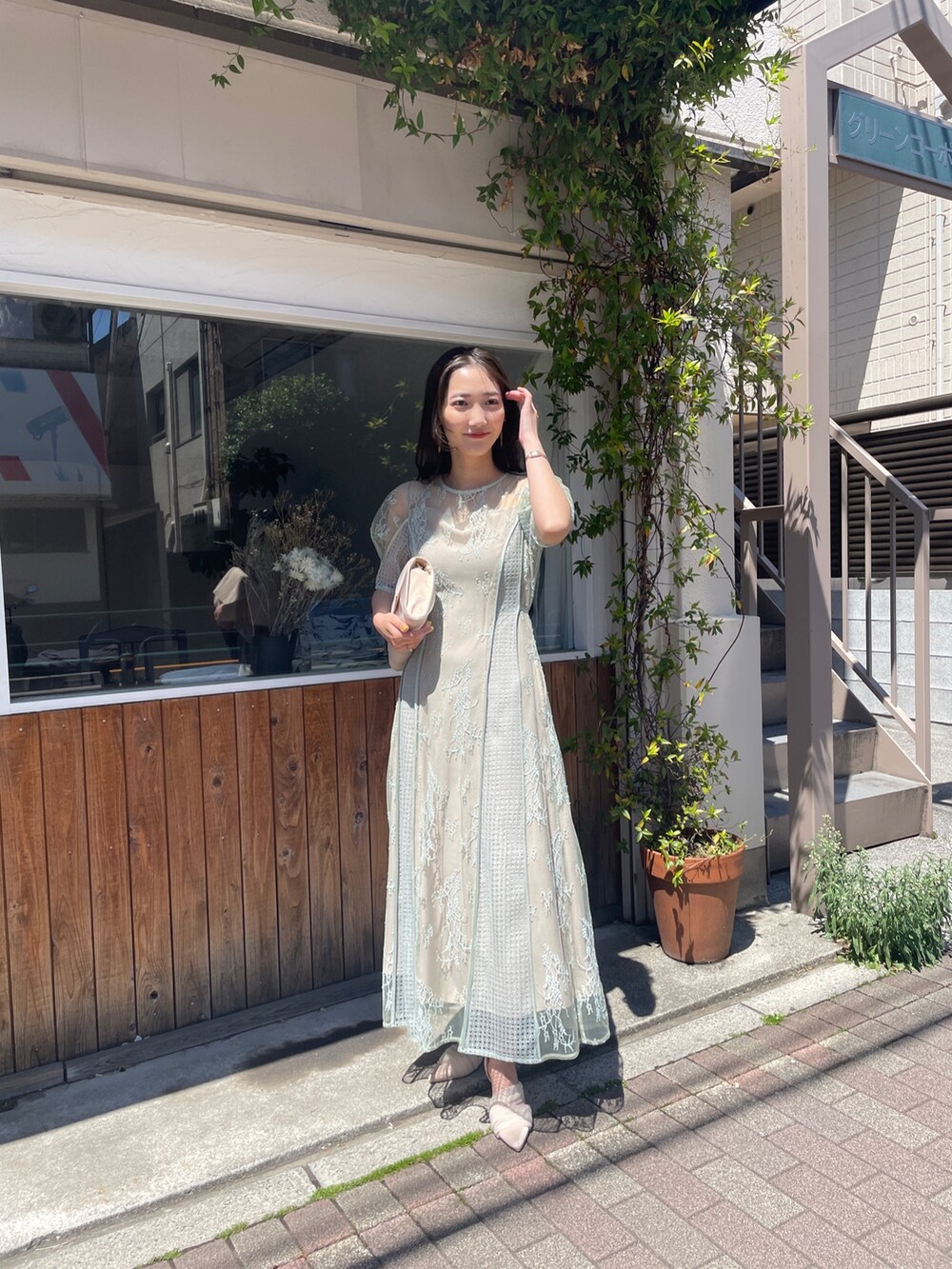 グリーン系のドレス、ベージュ系のハンドバッグ、ベージュ系のパンプスを着用したレディースの春コーディネートの4枚目の写真