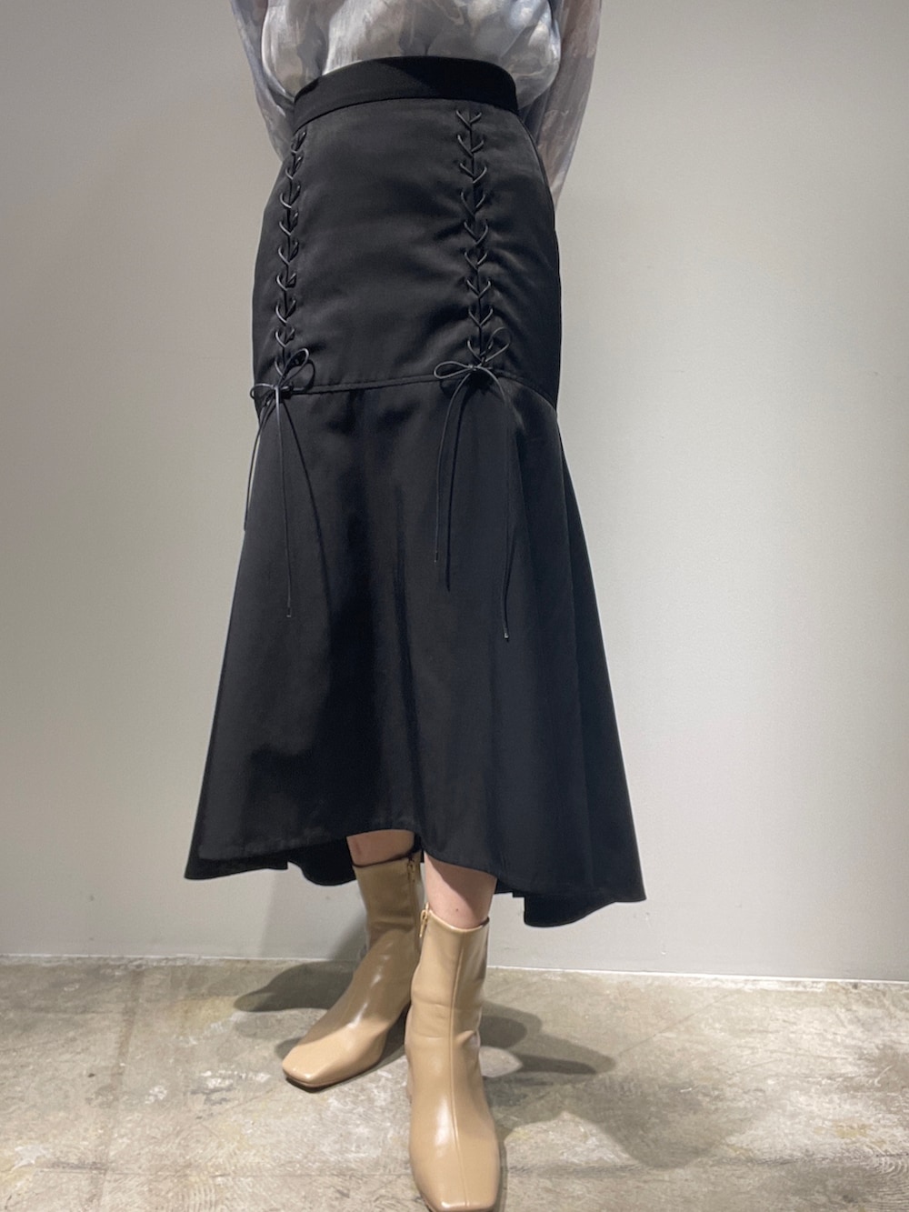 ブラック系のスカート、ベージュ系のブーツ、パープル系のシャツ/ブラウスを着用したレディースの夏コーディネートの7枚目の写真