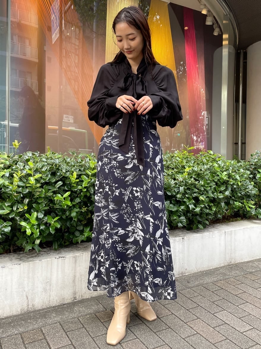 ブラック系のシャツ/ブラウス、ブルー系のスカート、ブルー系のスカートを着用したレディースの秋コーディネートの2枚目の写真