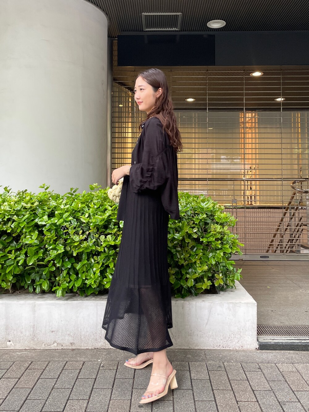 ブラック系のシャツ/ブラウス、ベージュ系のハンドバッグ、ブラック系のワンピースを着用したレディースの春コーディネートの3枚目の写真