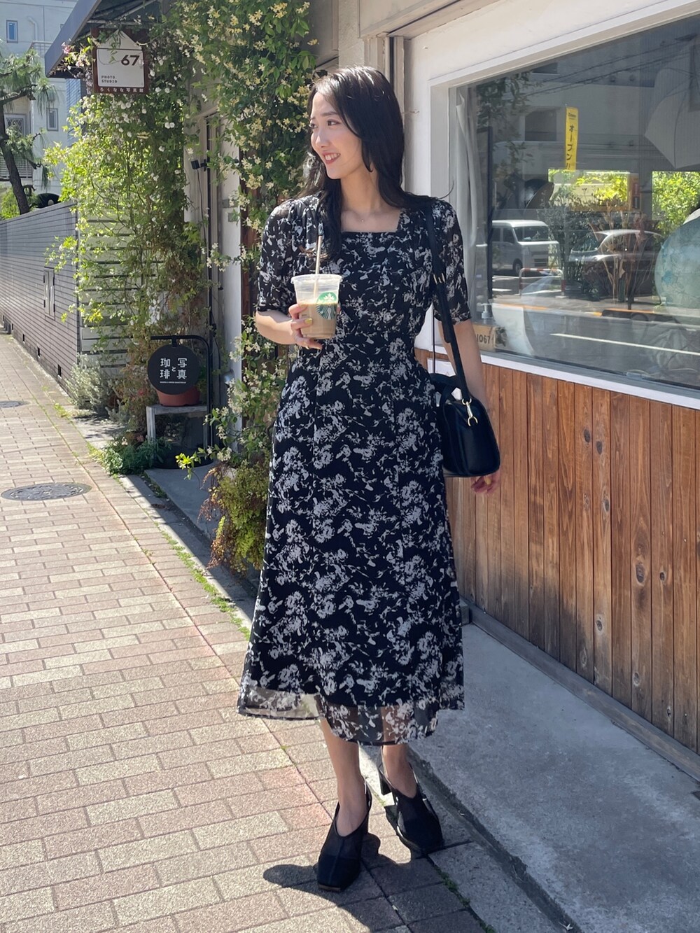 ブラック系のショルダーバッグ、ブラック系のワンピース、ブラック系のパンプスを着用したレディースの春コーディネートの4枚目の写真