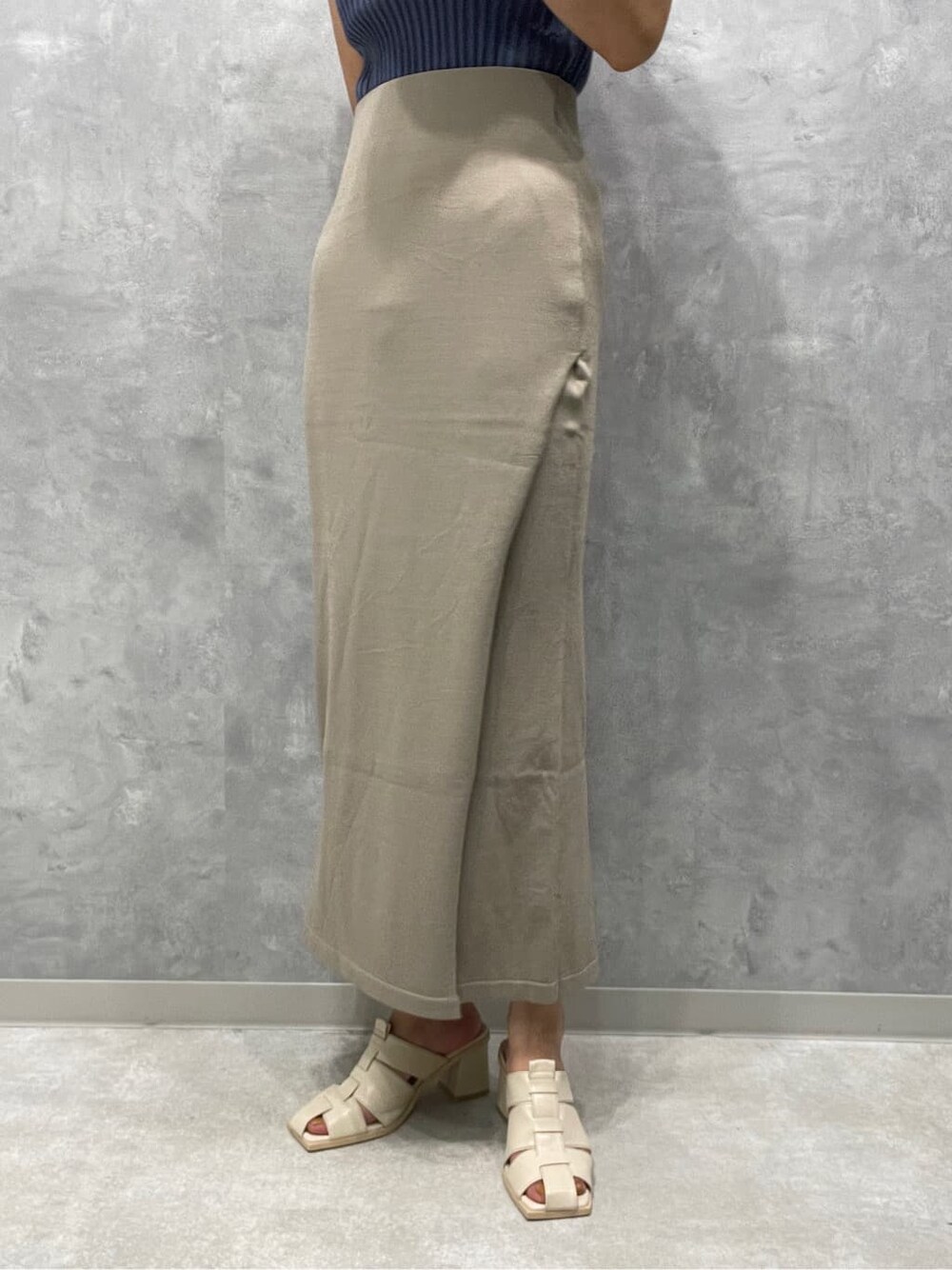 ホワイト系のサンダル、ベージュ系のスカート、ブルー系のニット/セーターを着用したレディースの夏コーディネートの7枚目の写真