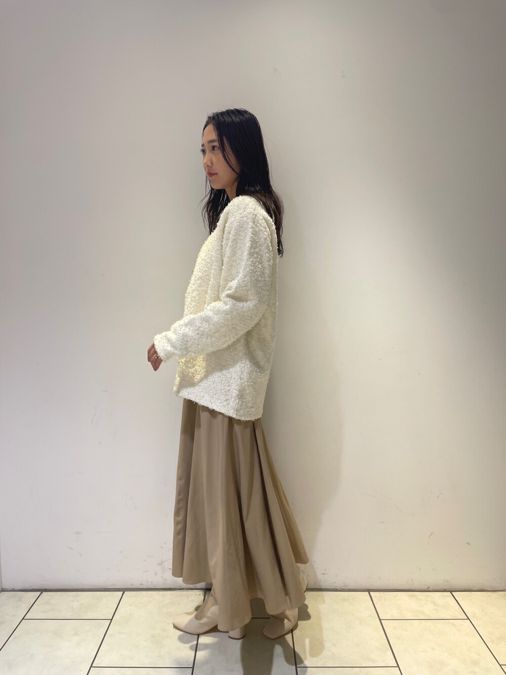 ベージュ系のワンピース、ホワイト系のブーツ、ホワイト系のカーディガン/ボレロを着用したレディースの秋コーディネートの4枚目の写真