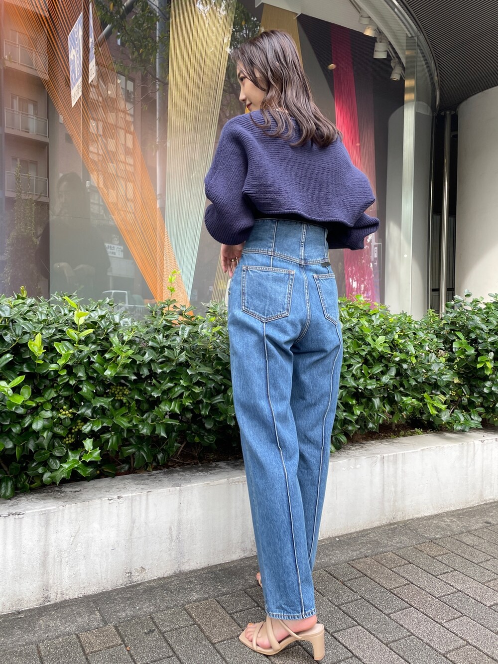 ベージュ系のサンダル、ブルー系のデニムパンツ、ブラック系のニット/セーターを着用したレディースの冬コーディネートの4枚目の写真