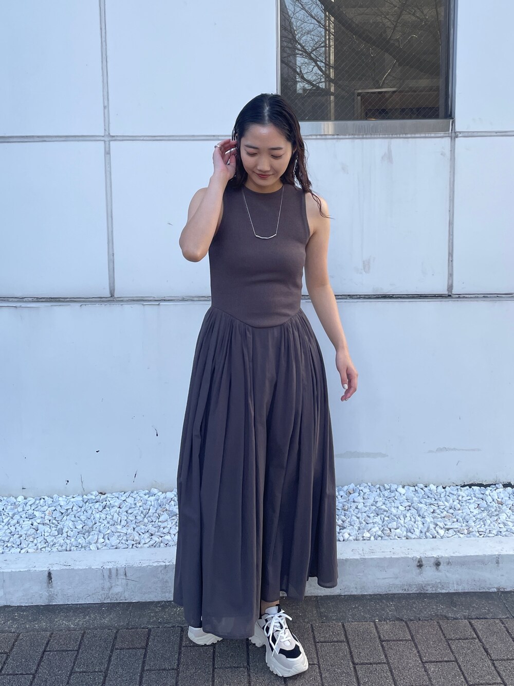 グレー系のワンピース、ブラック系のスニーカーを着用したレディースの春コーディネートの5枚目の写真
