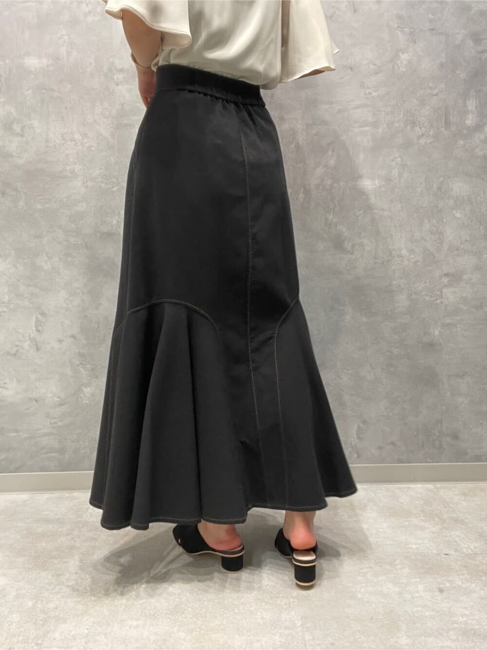 ブラック系のサンダル、ブラック系のスカート、ホワイト系のシャツ/ブラウスを着用したレディースの夏コーディネートの9枚目の写真