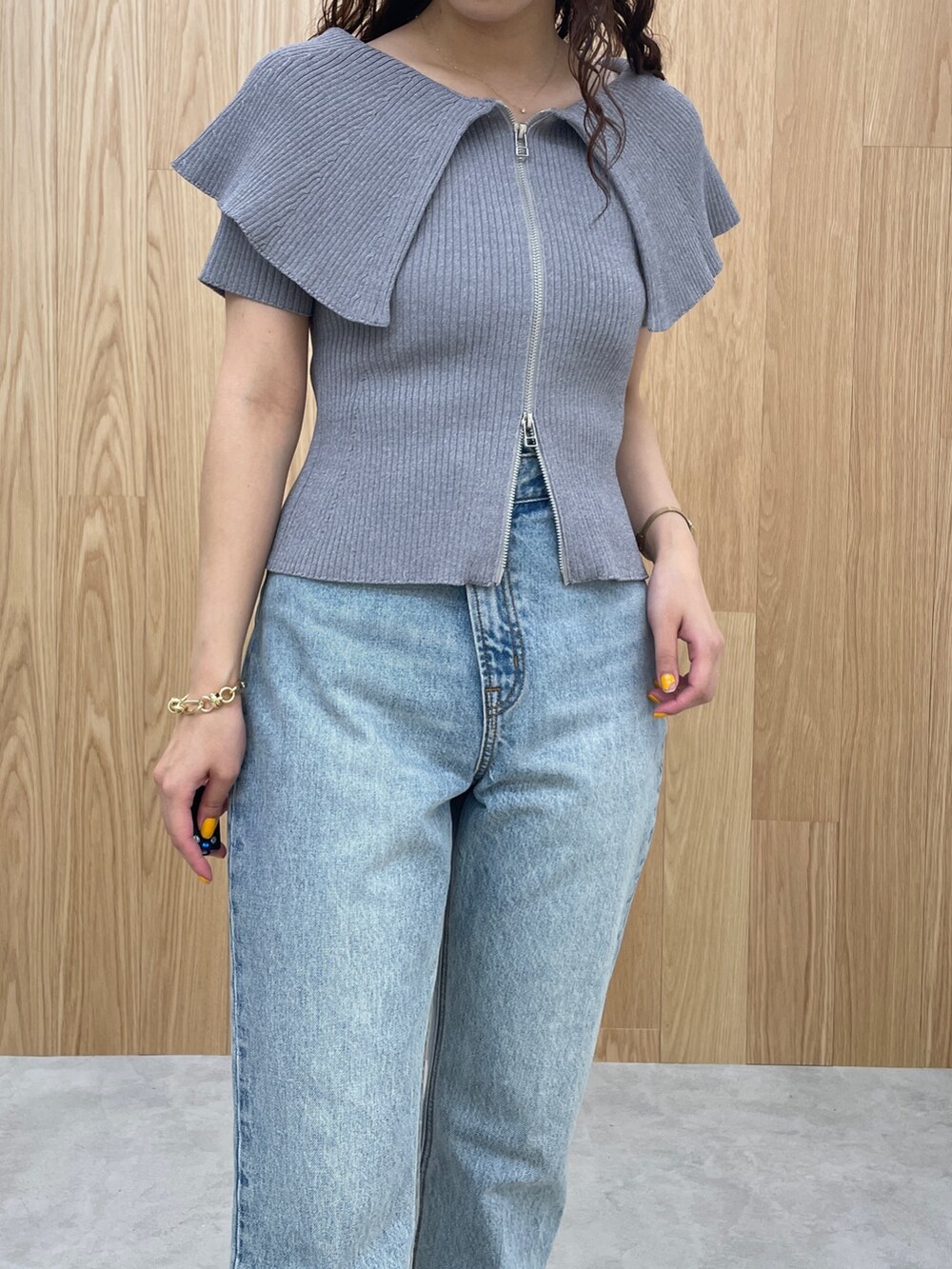 ブルー系のデニムパンツ、グレー系のニット/セーター、シルバー系のパンプスを着用したレディースの春コーディネートの6枚目の写真