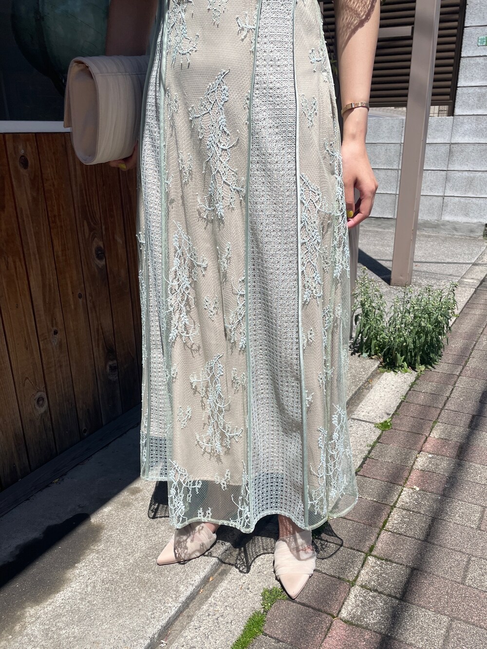 グリーン系のドレス、ベージュ系のハンドバッグ、ベージュ系のパンプスを着用したレディースの春コーディネートの9枚目の写真