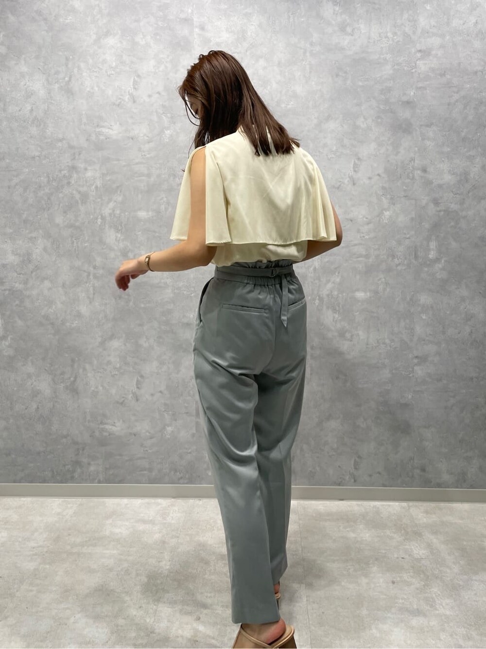 ブルー系のスラックス、ベージュ系のサンダル、ホワイト系のシャツ/ブラウスを着用したレディースの夏コーディネートの4枚目の写真