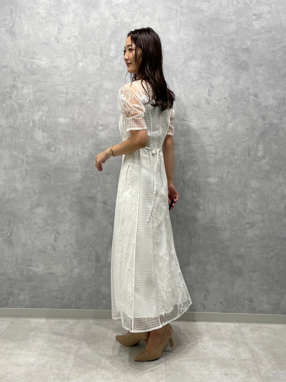 ベージュ系のその他アウター、ゴールド系のパンプス、ホワイト系のドレスを着用したレディースの冬コーディネートの5枚目の写真