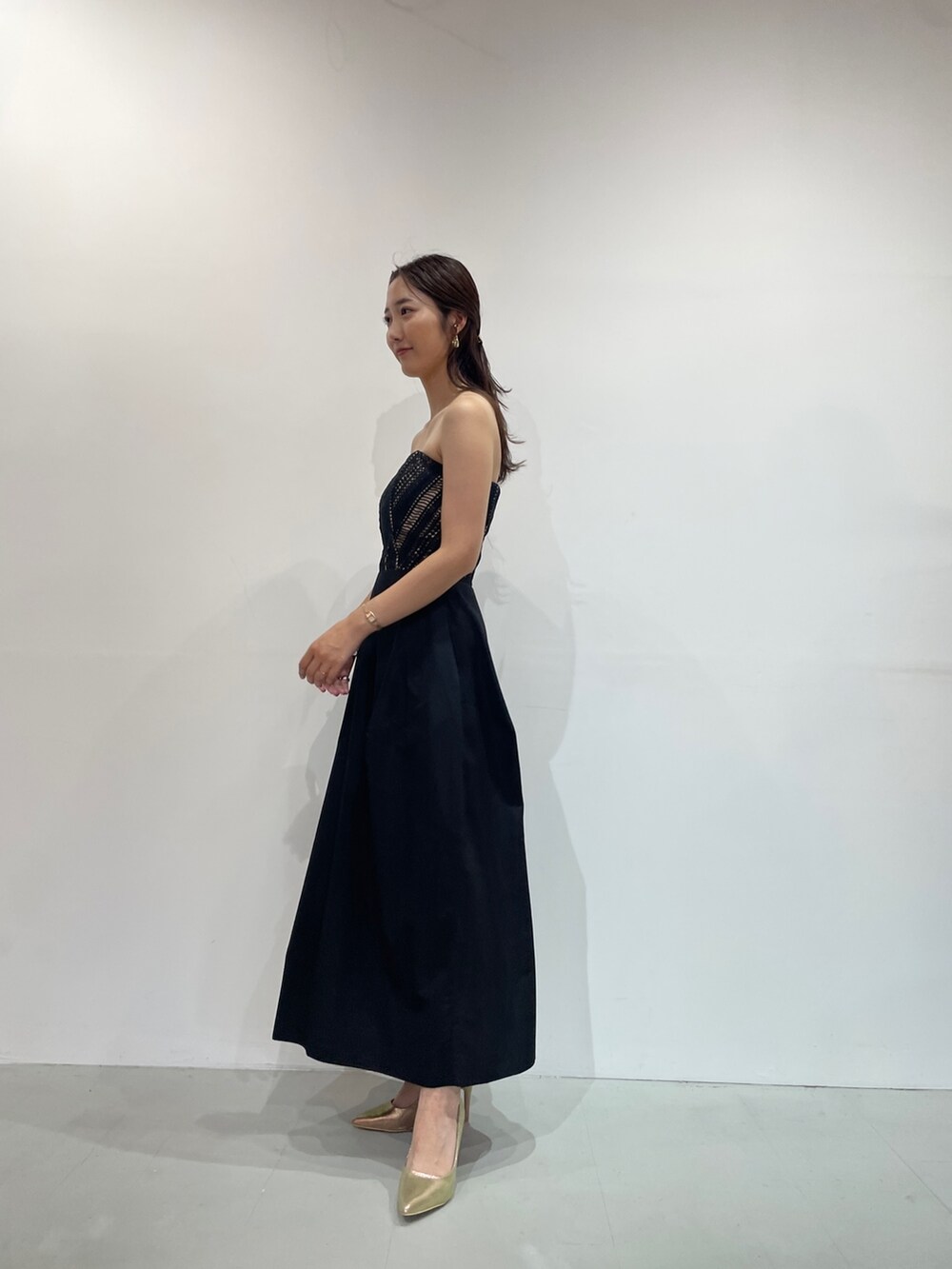 ブラック系のドレス、ゴールド系のパンプスを着用したレディースの夏コーディネートの5枚目の写真