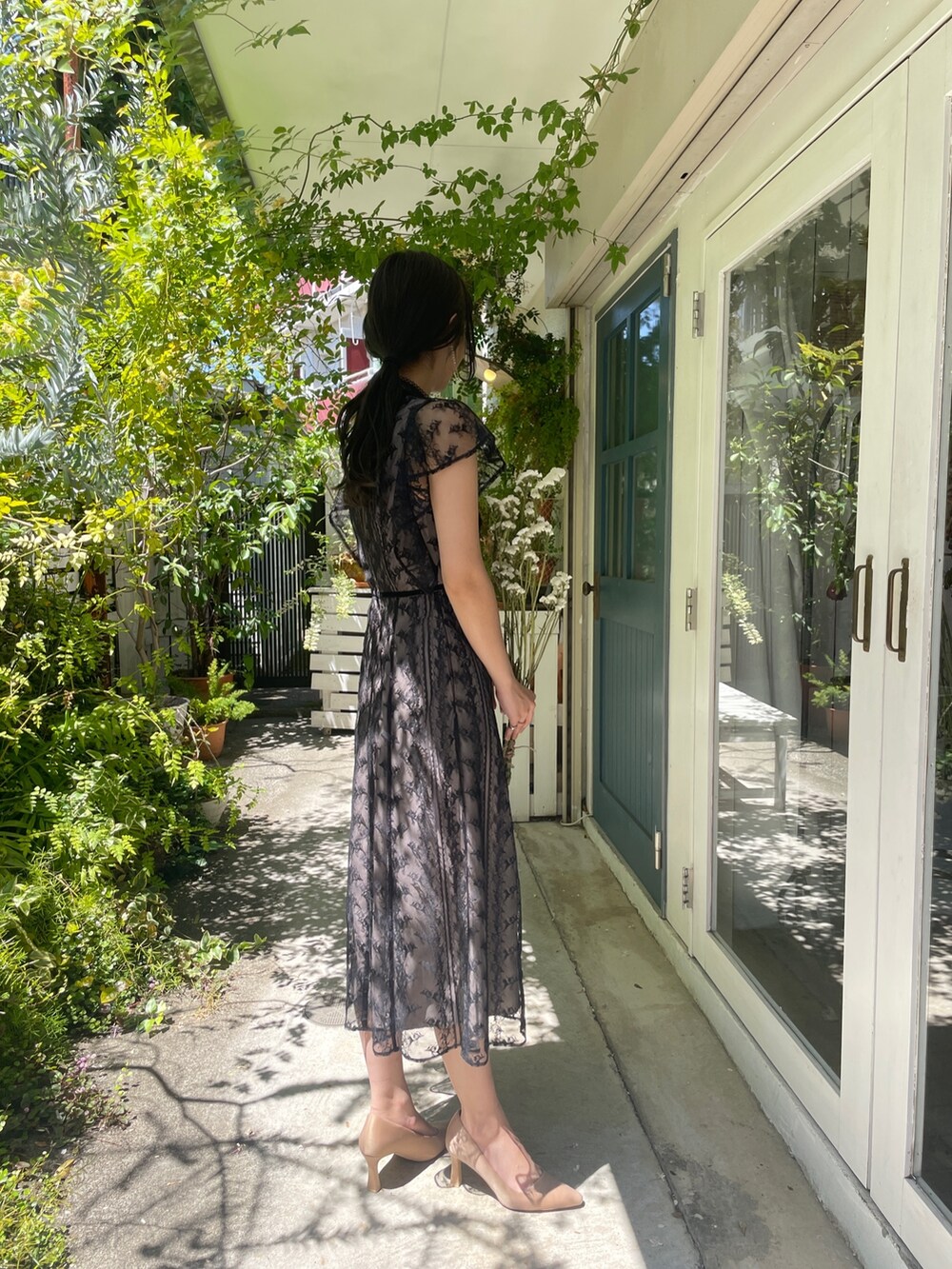 ゴールド系のパンプス、ブラック系のドレスを着用したレディースの夏コーディネートの6枚目の写真