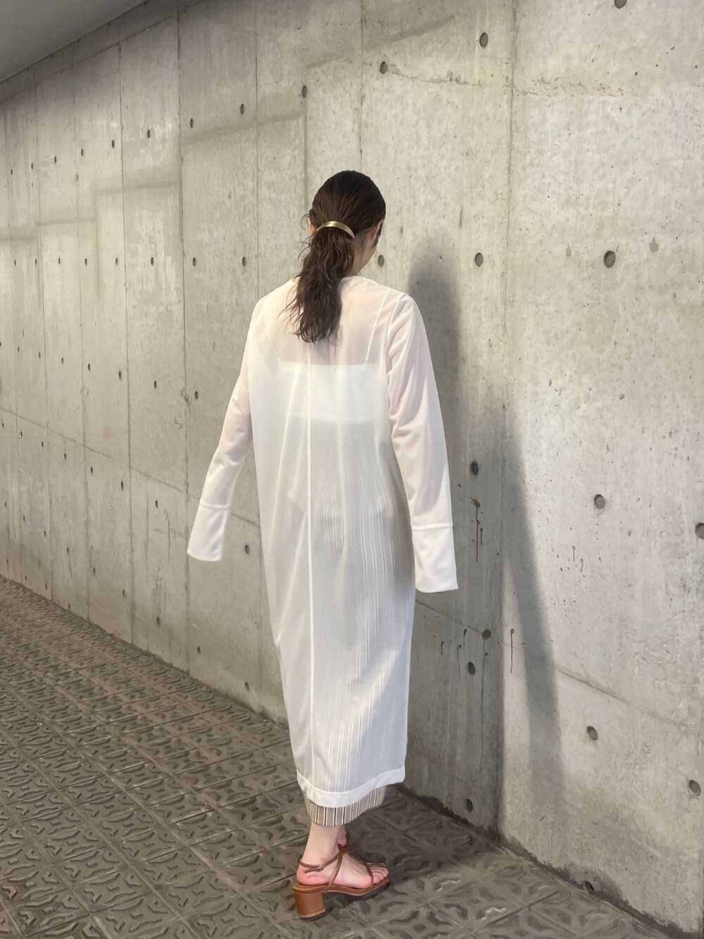 ホワイト系のTシャツ/カットソー、ベージュ系のスカート、ブラウン系のサンダルを着用したレディースの春コーディネートの7枚目の写真