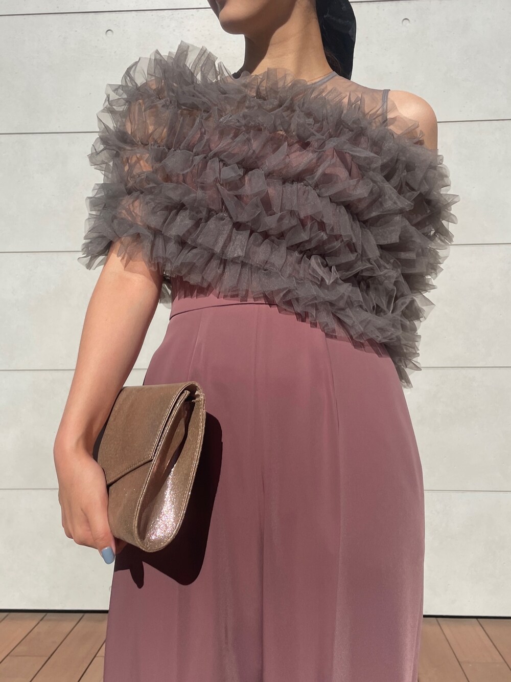 ピンク系のパンツドレス、ゴールド系のハンドバッグ、ベージュ系のパンプスを着用したレディースの秋コーディネートの10枚目の写真