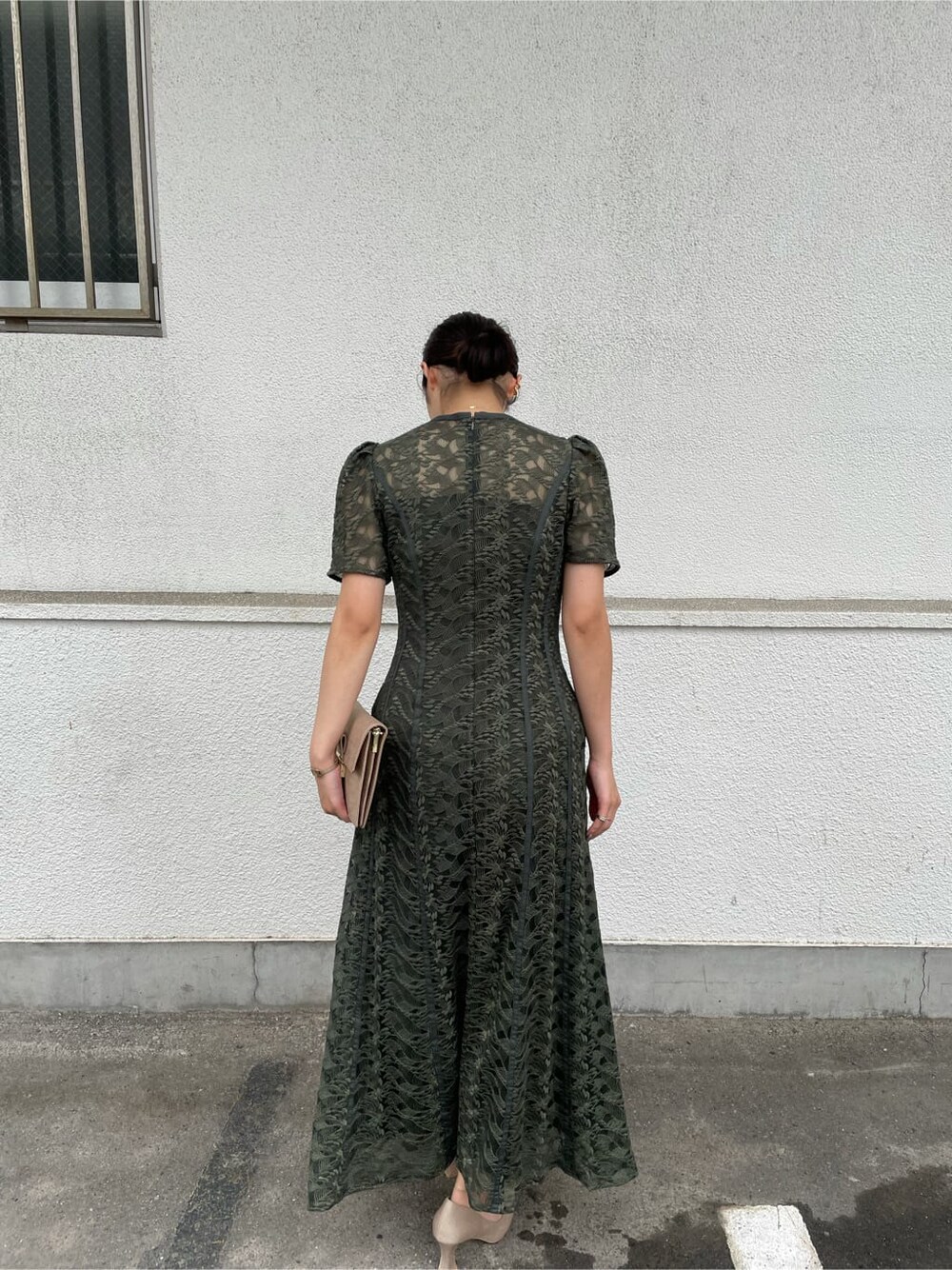 グリーン系のドレス、ベージュ系のパンプス、ブラウン系のクラッチバッグを着用したレディースの夏コーディネートの7枚目の写真