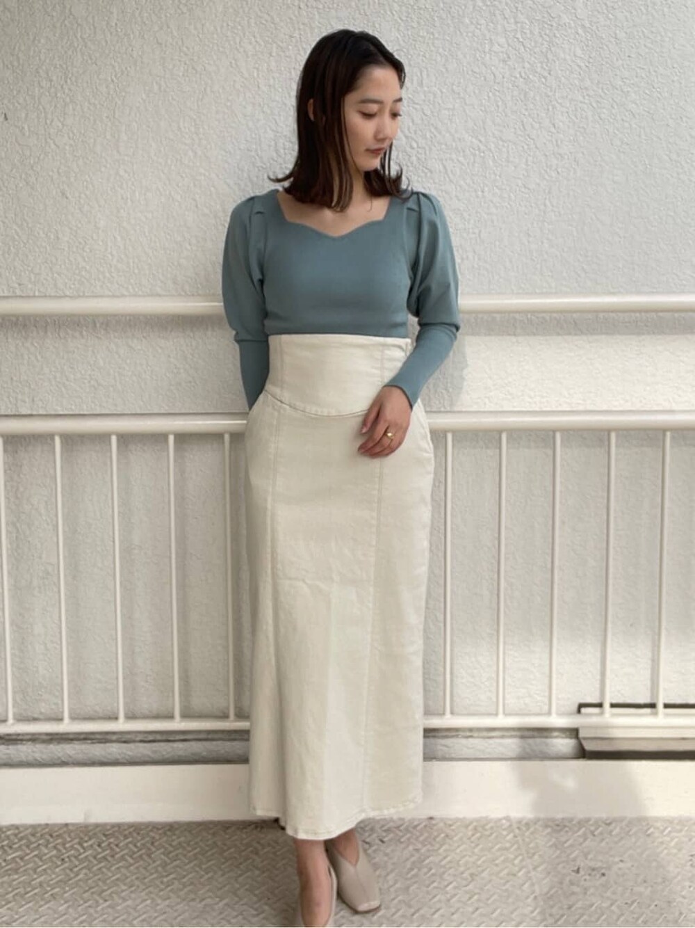 ホワイト系のブルゾン、ホワイト系のスカート、ホワイト系のパンプスを着用したレディースの冬コーディネートの5枚目の写真