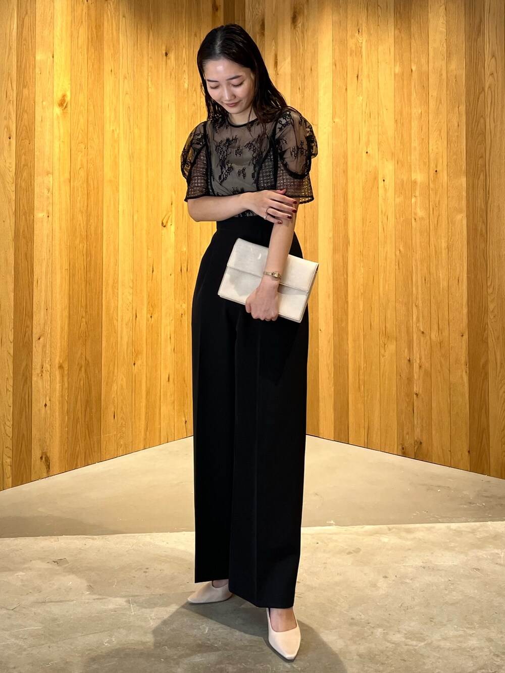 ベージュ系のパンプス、ベージュ系のクラッチバッグ、ブラック系のパンツドレスを着用したレディースの冬コーディネートの3枚目の写真