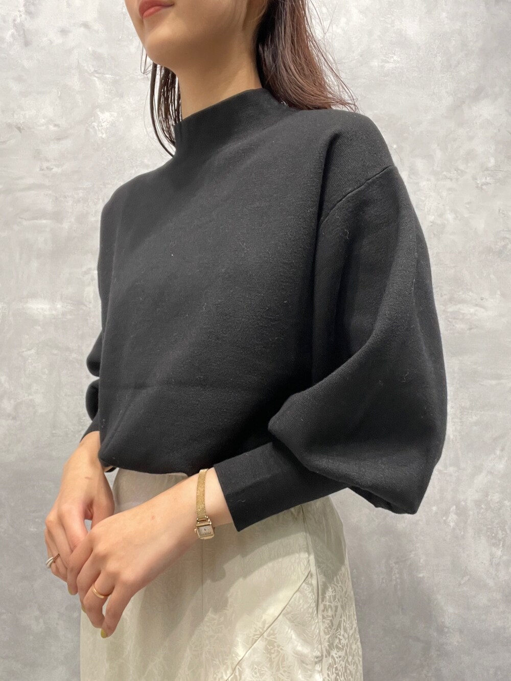 ブラック系のニット/セーター、ホワイト系のスカート、ベージュ系のブーツを着用したレディースの冬コーディネートの8枚目の写真