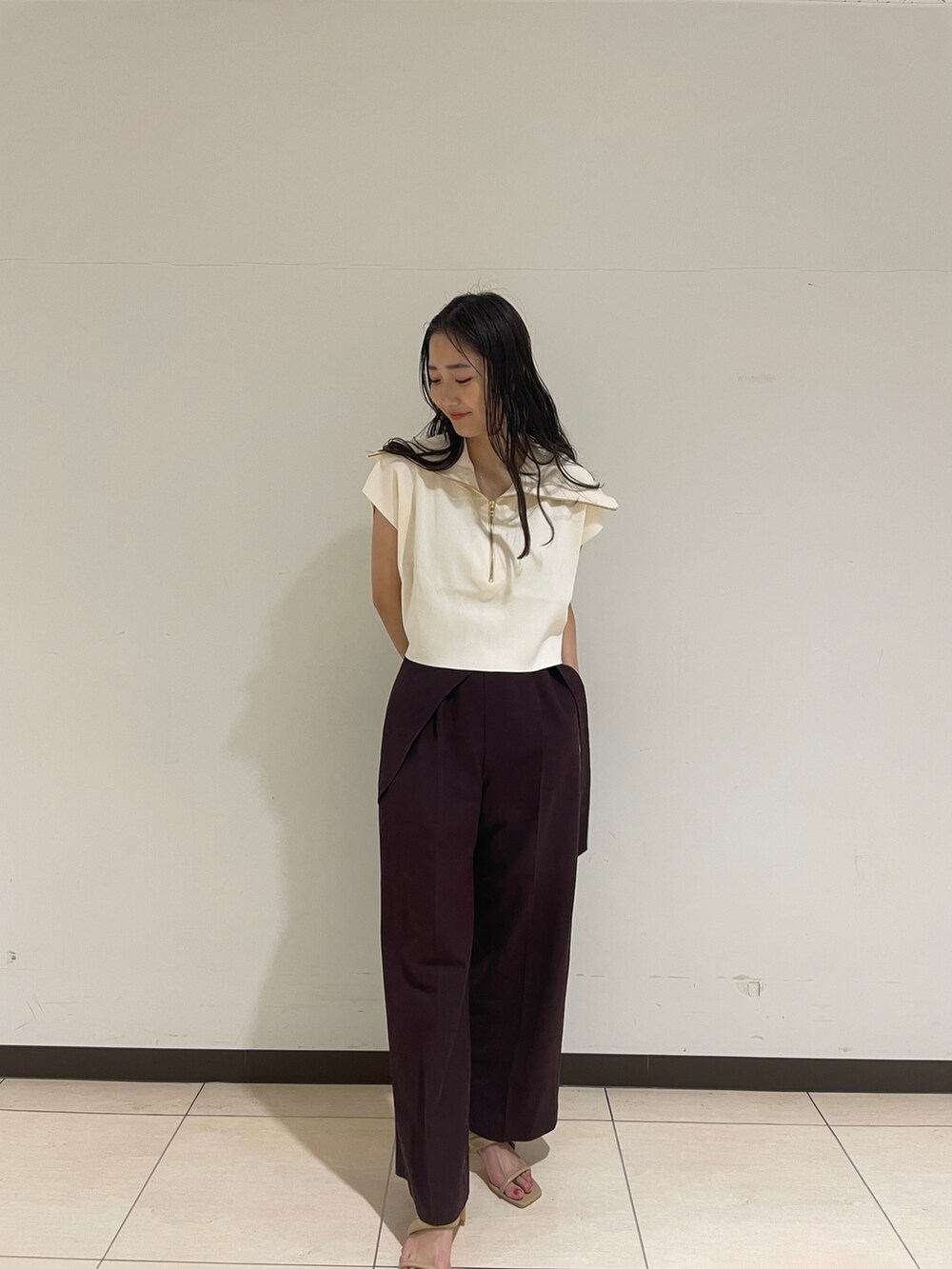 ブラウン系のその他パンツ、ホワイト系のニット/セーター、ベージュ系のサンダルを着用したレディースの春コーディネートの4枚目の写真