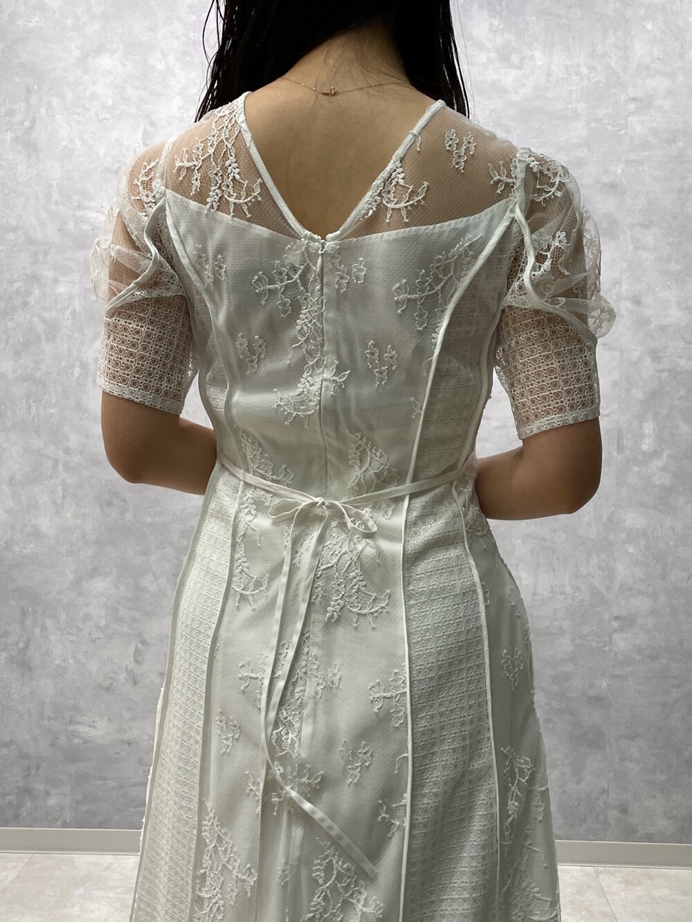 ベージュ系のその他アウター、ゴールド系のパンプス、ホワイト系のドレスを着用したレディースの冬コーディネートの9枚目の写真