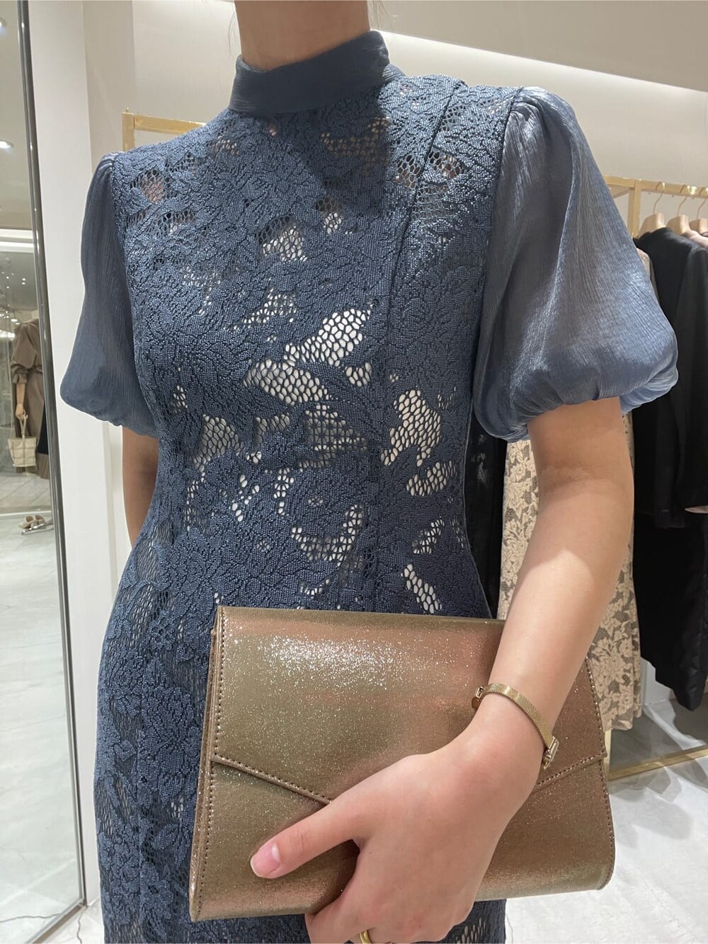 ゴールド系のクラッチバッグ、ブルー系のドレスを着用したレディースの春コーディネートの6枚目の写真