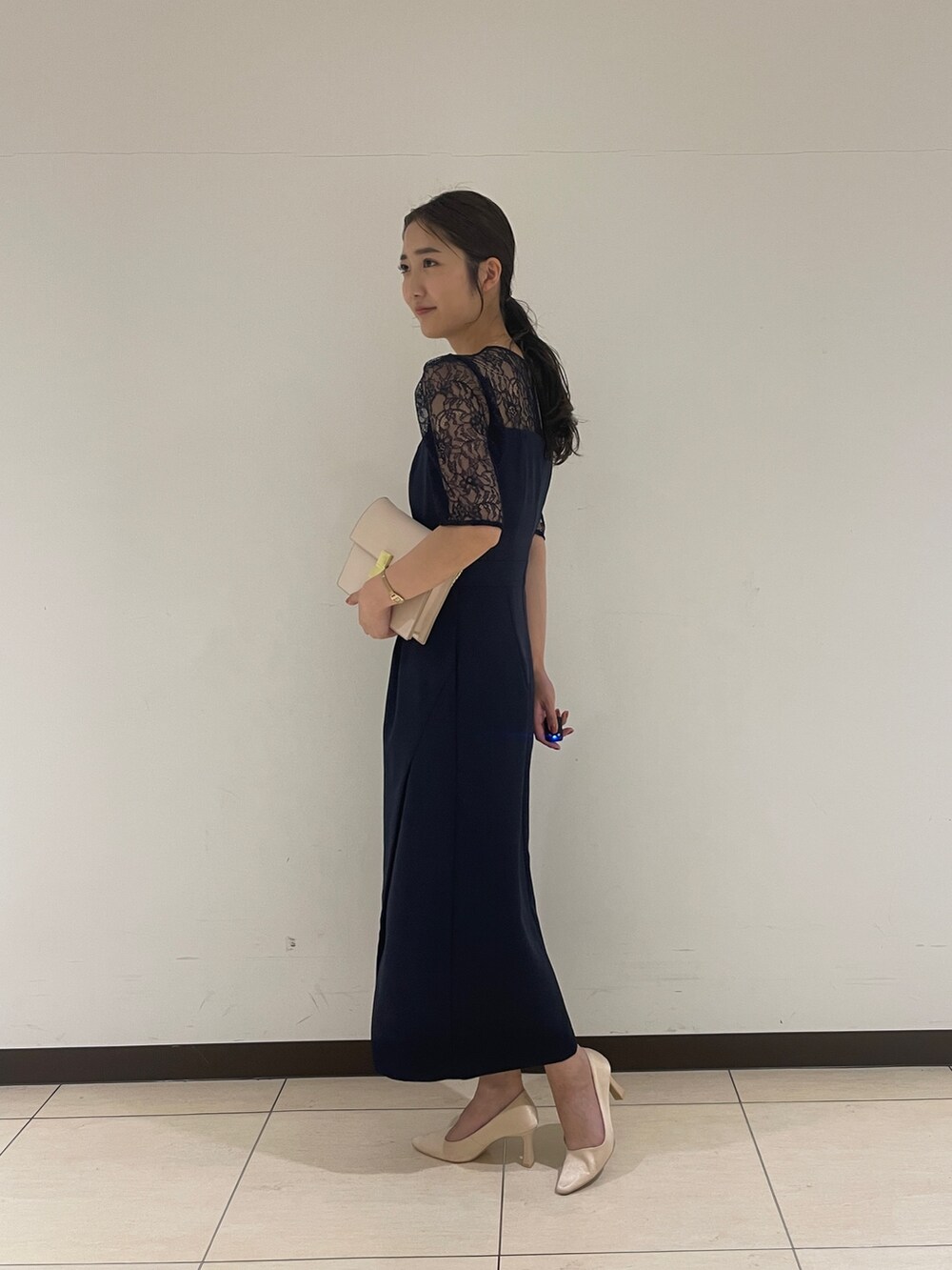 ゴールド系のクラッチバッグ、ベージュ系のパンプス、ブルー系のドレスを着用したレディースの春コーディネートの7枚目の写真