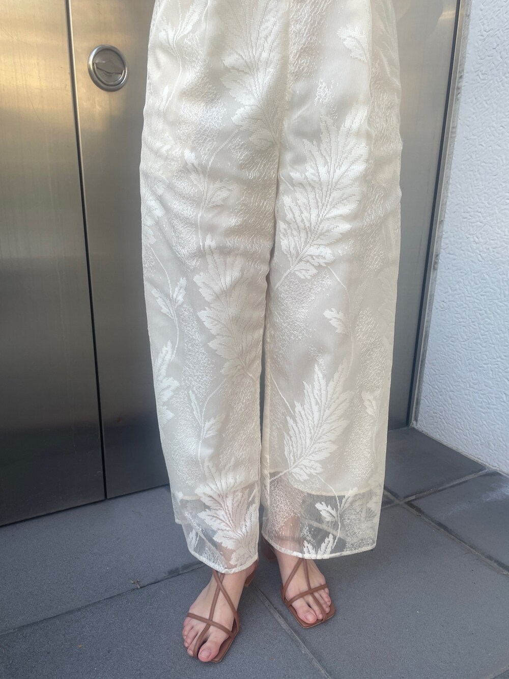 ブラウン系のサンダル、ホワイト系のつなぎ/オールインワン、ベージュ系の折りたたみ傘を着用したレディースの冬コーディネートの9枚目の写真