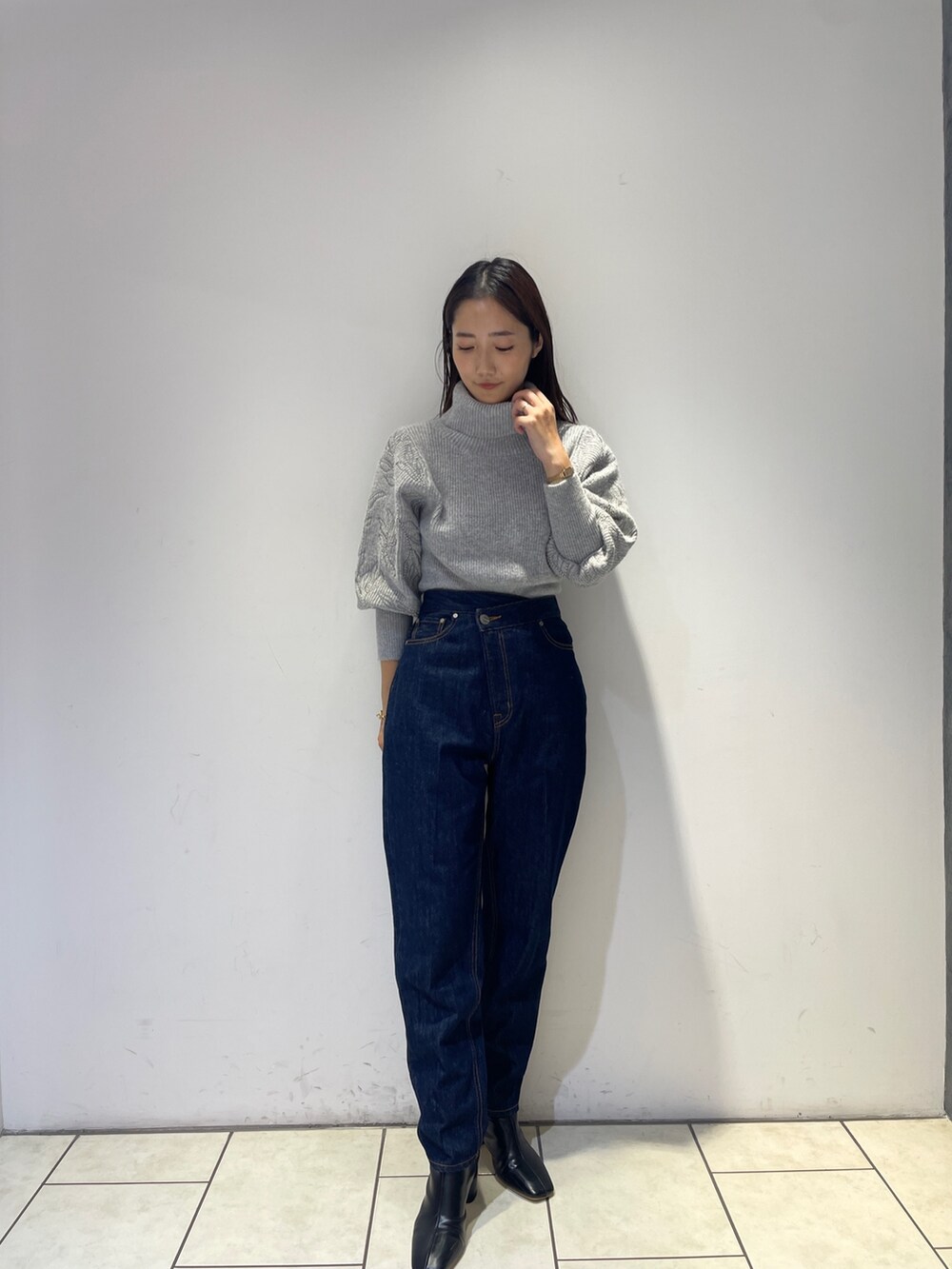ブラック系のブーツ、ブルー系のデニムパンツ、グレー系のニット/セーターを着用したレディースの秋コーディネートの5枚目の写真