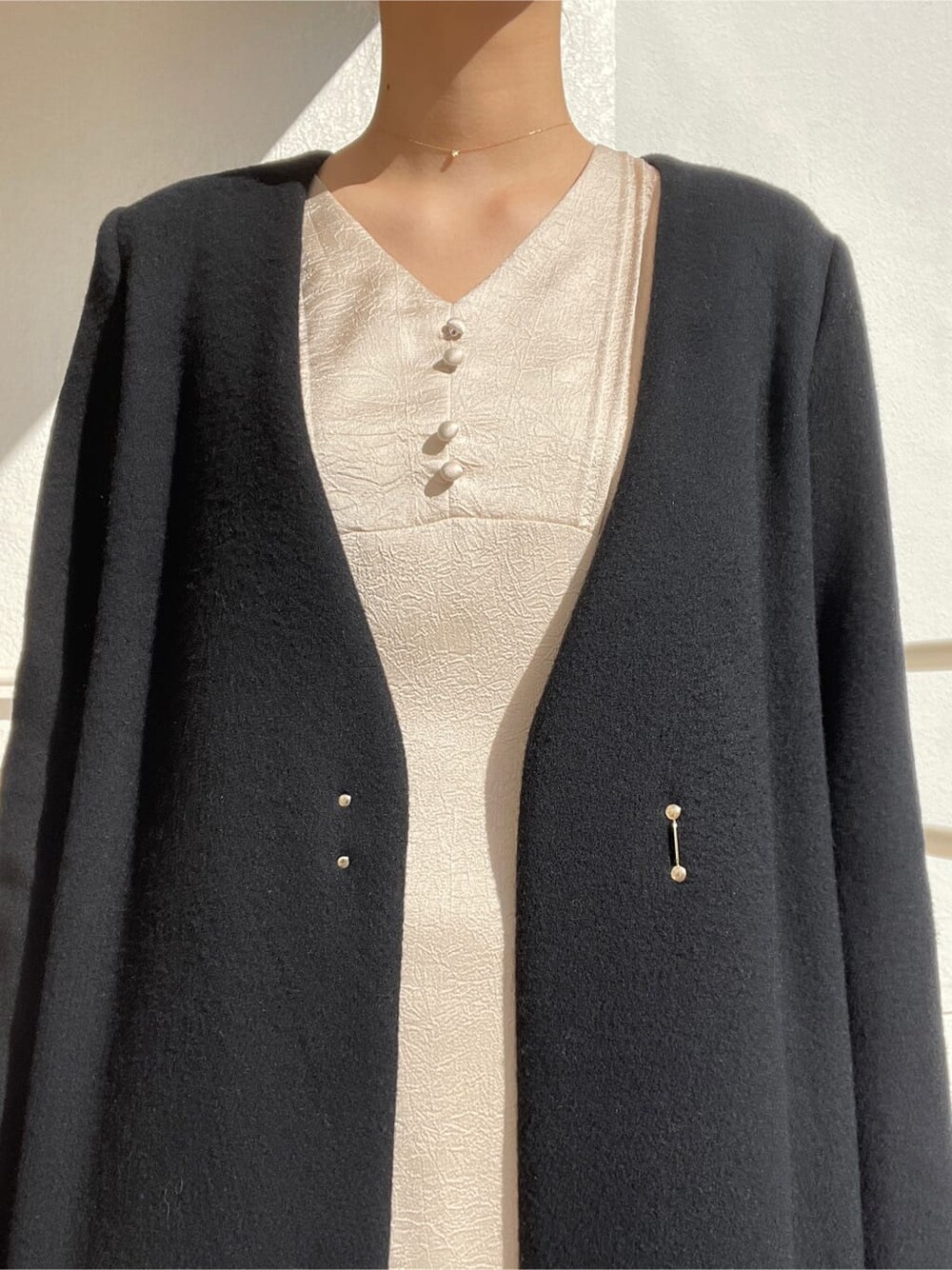 ブラック系のその他シューズ、ブラック系のその他アウター、ホワイト系のワンピースを着用したレディースの冬コーディネートの9枚目の写真