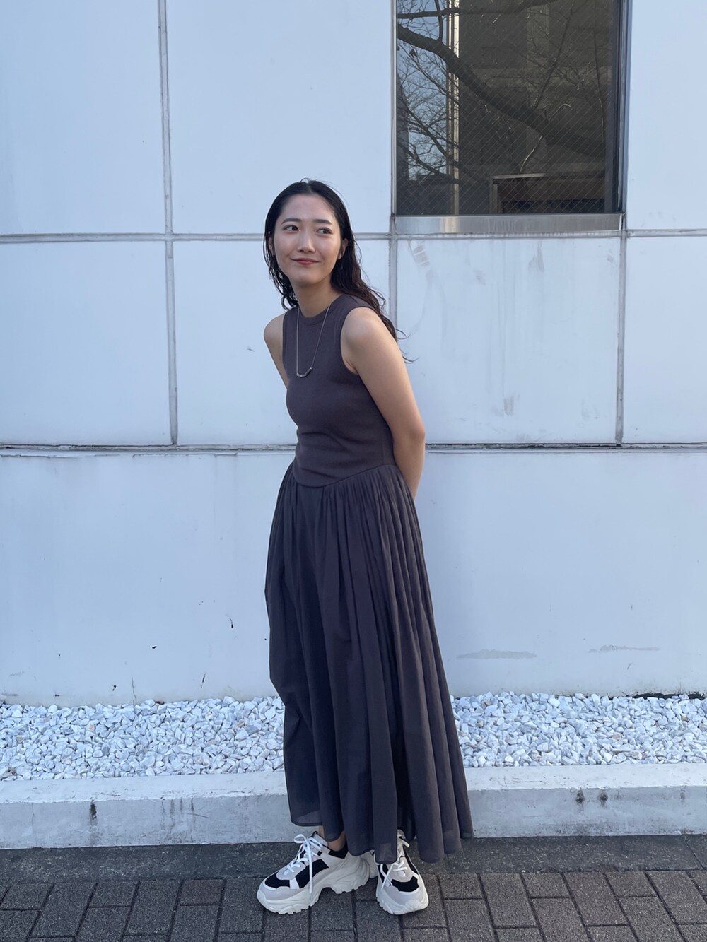グレー系のワンピース、ブラック系のスニーカーを着用したレディースの春コーディネートの3枚目の写真