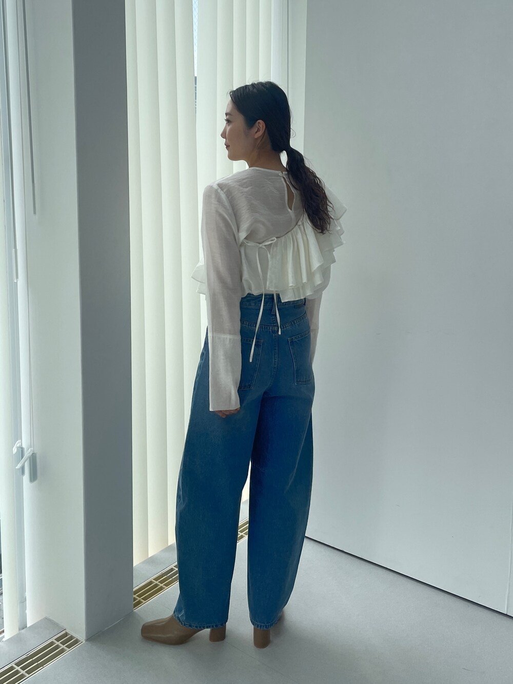 ベージュ系のブーツ、ホワイト系のシャツ/ブラウス、ブルー系のデニムパンツを着用したレディースの夏コーディネートの5枚目の写真