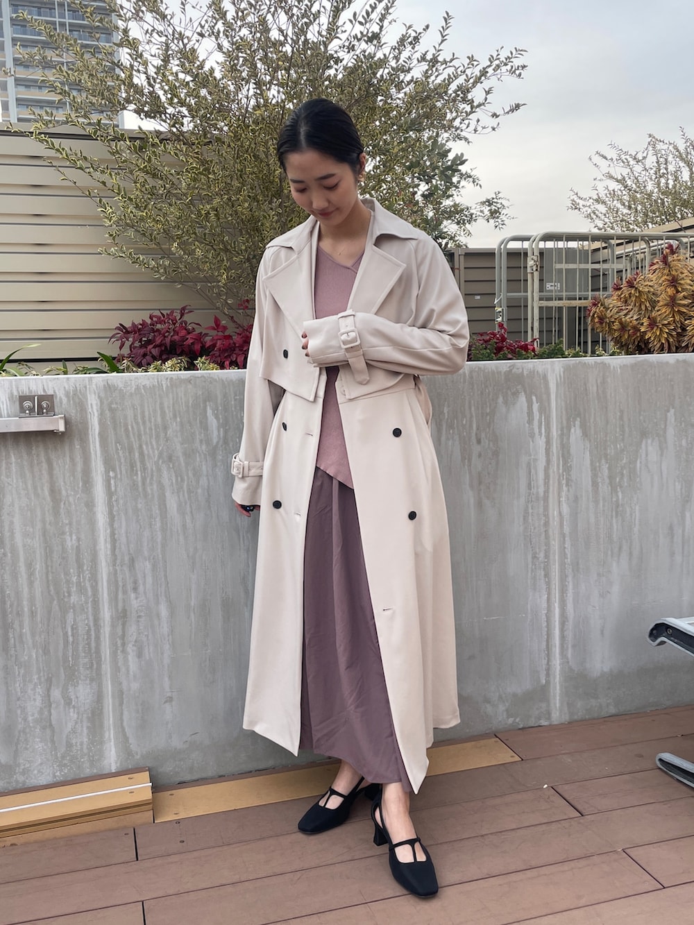 ホワイト系のトレンチコート、ブラック系のパンプス、ピンク系のワンピースを着用したレディースの冬コーディネートの3枚目の写真