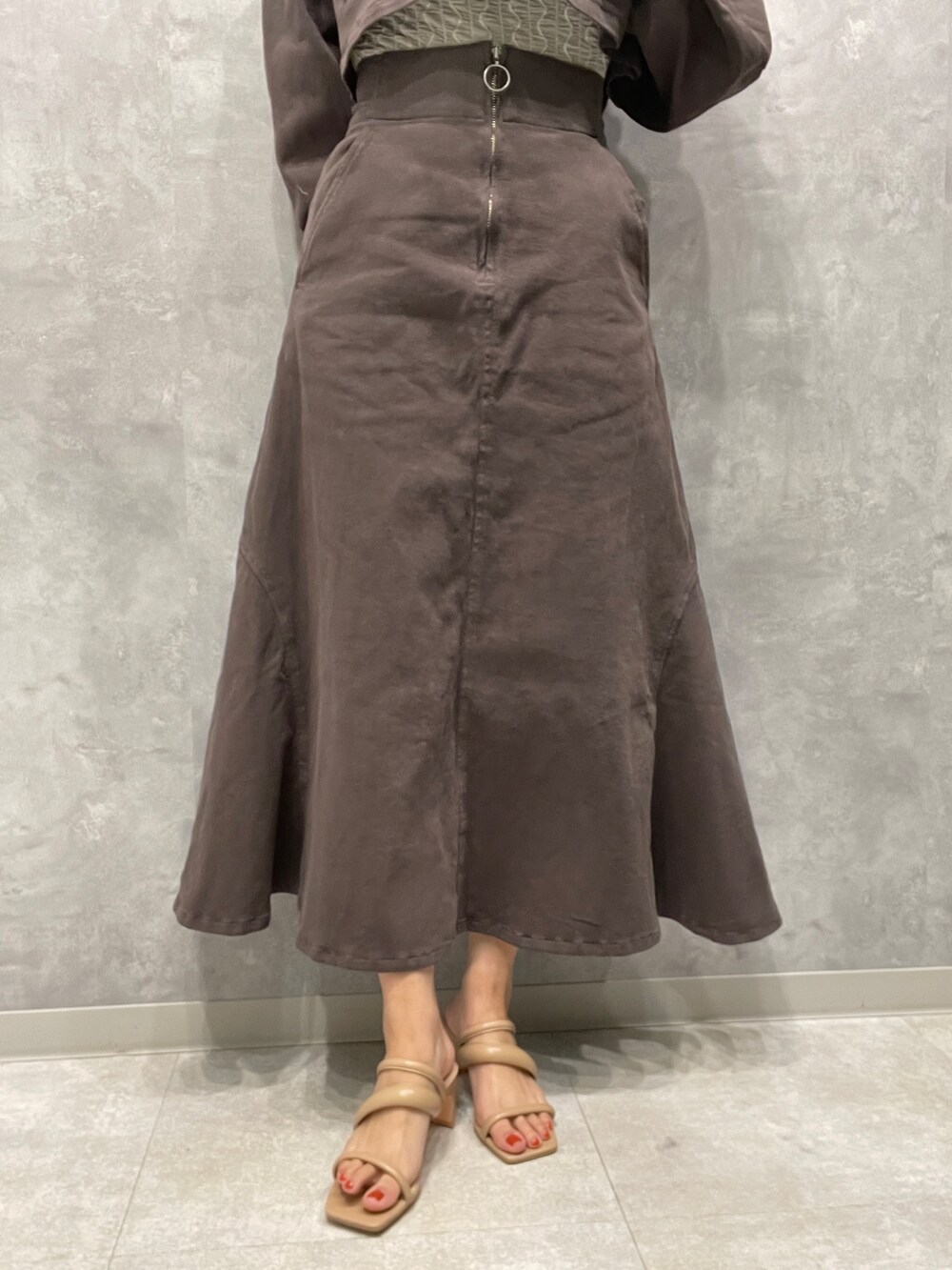 ベージュ系のサンダル、グレー系のスカート、ホワイト系のTシャツ/カットソーを着用したレディースの春コーディネートの9枚目の写真