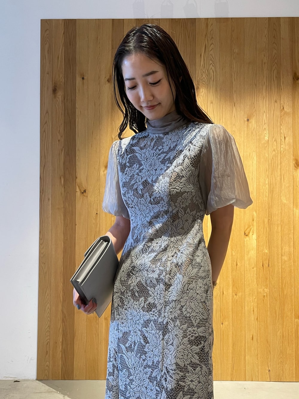 グレー系のパンプス、グレー系のクラッチバッグ、グレー系のドレスを着用したレディースの冬コーディネートの6枚目の写真