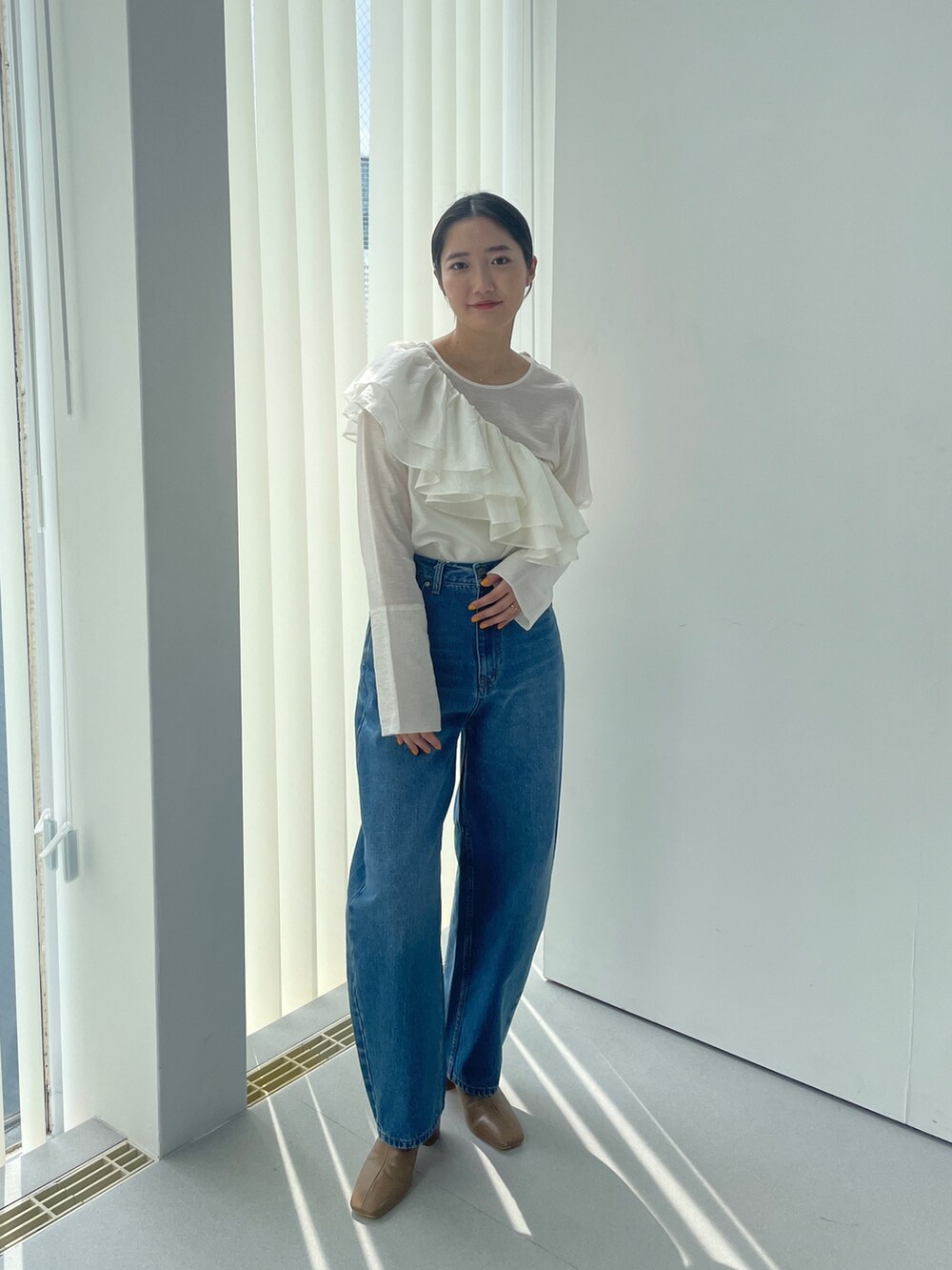 ベージュ系のブーツ、ホワイト系のシャツ/ブラウス、ブルー系のデニムパンツを着用したレディースの夏コーディネートの3枚目の写真