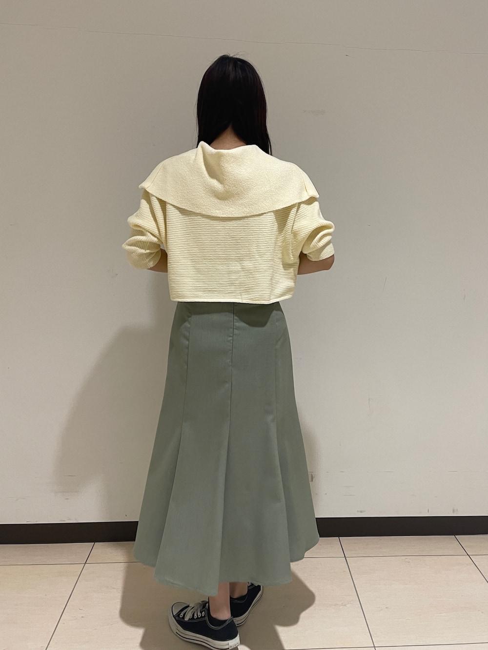 ホワイト系のカーディガン/ボレロ、グリーン系のスカートを着用したレディースの春コーディネートの5枚目の写真