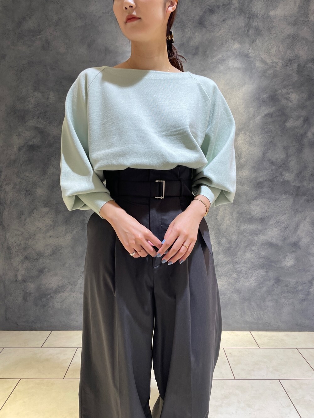 グレー系のその他パンツ、ホワイト系のブーツ、グリーン系のニット/セーターを着用したレディースの冬コーディネートの8枚目の写真