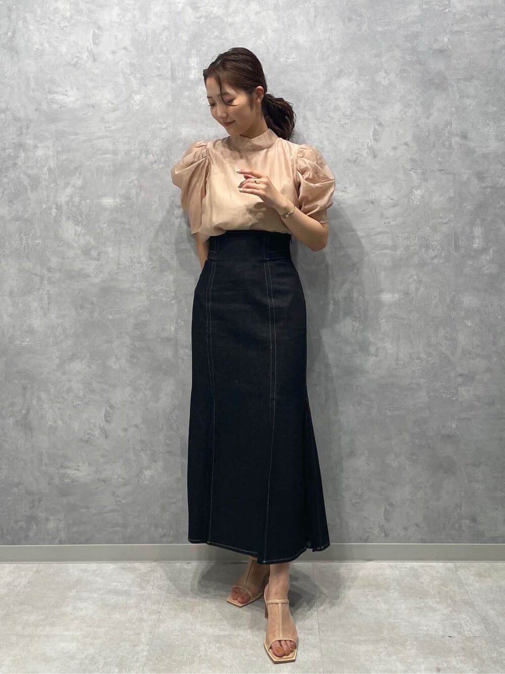 ベージュ系のシャツ/ブラウス、ブラック系のスカート、ベージュ系のサンダルを着用したレディースの春コーディネートの2枚目の写真