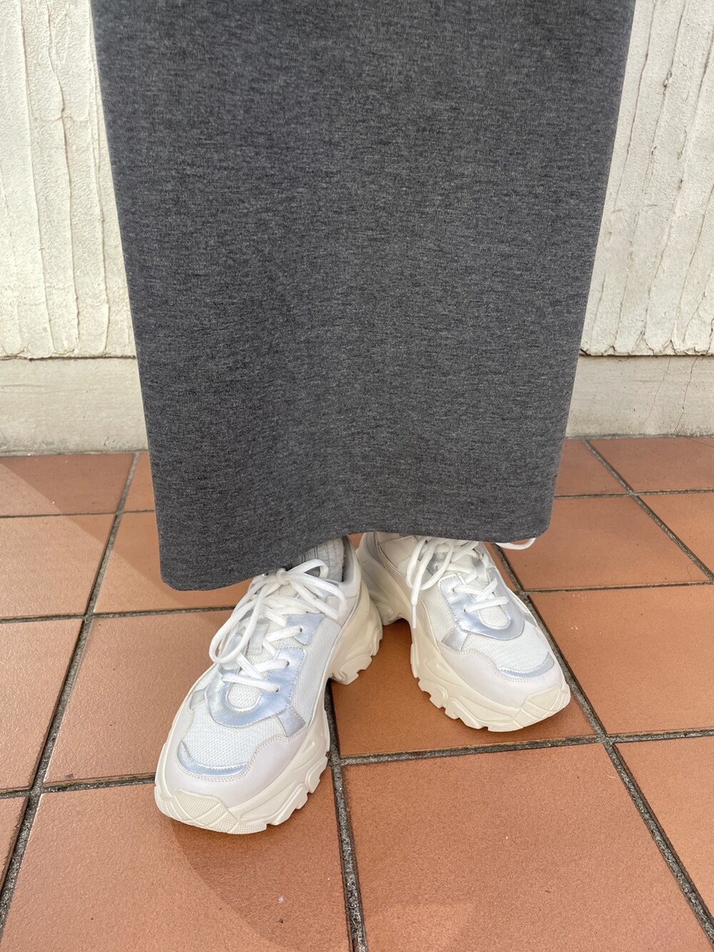 ホワイト系のスニーカー、グレー系のワンピース、グレー系のテーラードジャケットを着用したレディースの冬コーディネートの9枚目の写真