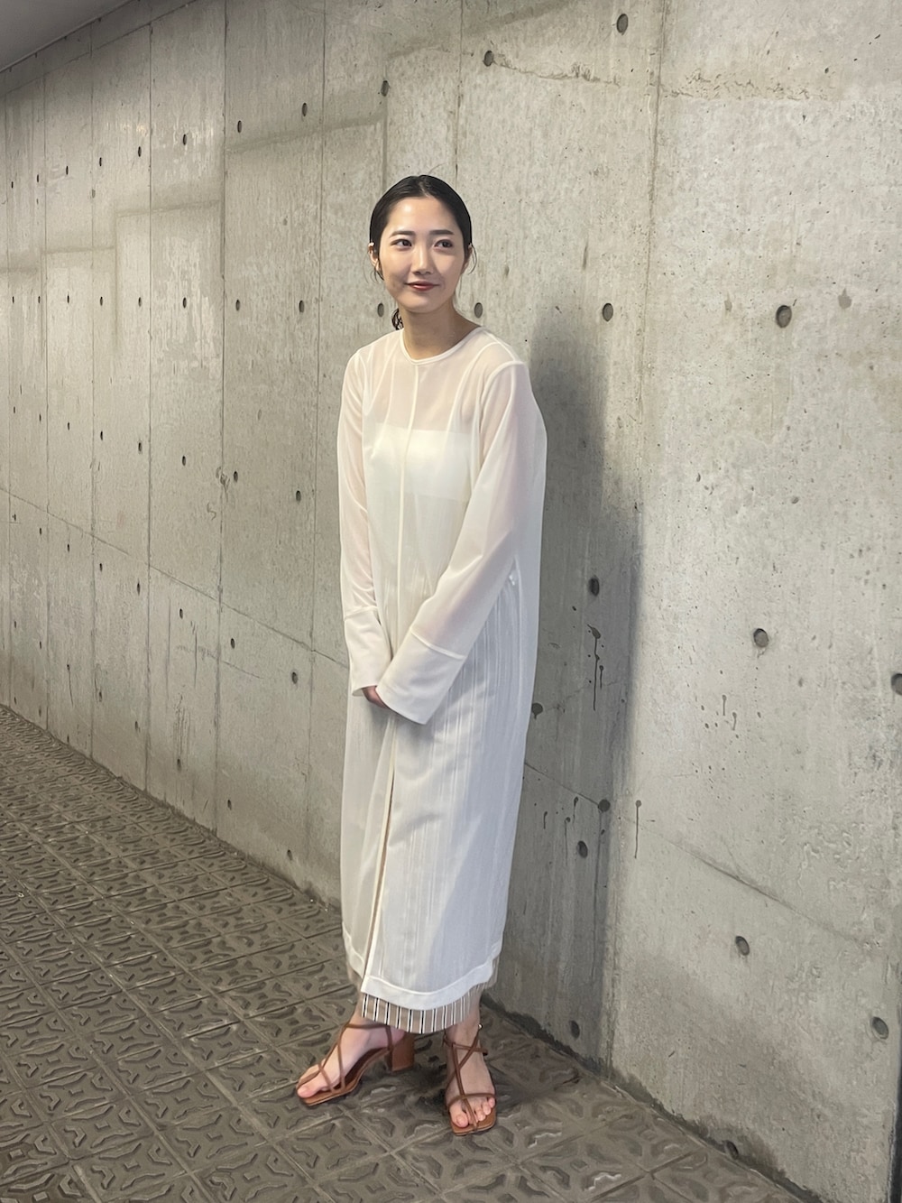 ホワイト系のTシャツ/カットソー、ベージュ系のスカート、ブラウン系のサンダルを着用したレディースの春コーディネートの2枚目の写真