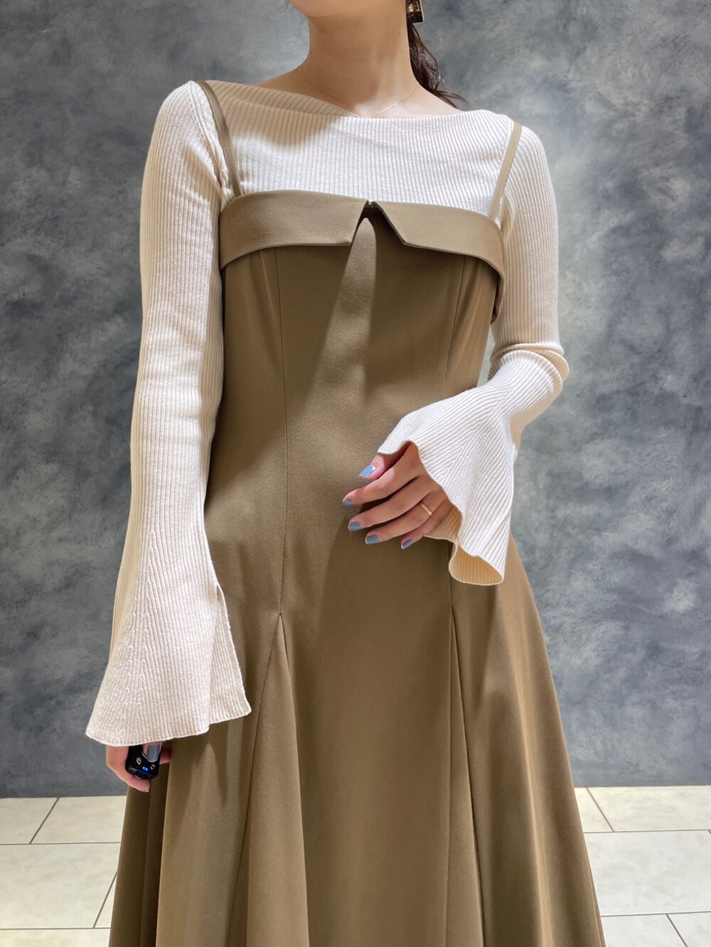 ホワイト系のニット/セーター、ベージュ系のワンピース、ホワイト系のブーツを着用したレディースの冬コーディネートの9枚目の写真