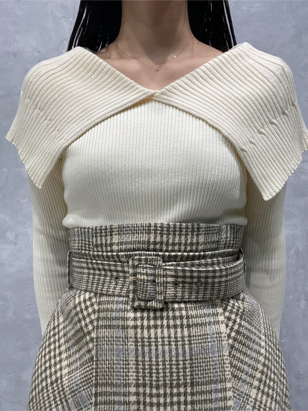 ブラック系のブーツ、ベージュ系のスカート、ホワイト系のニット/セーターを着用したレディースの秋コーディネートの7枚目の写真