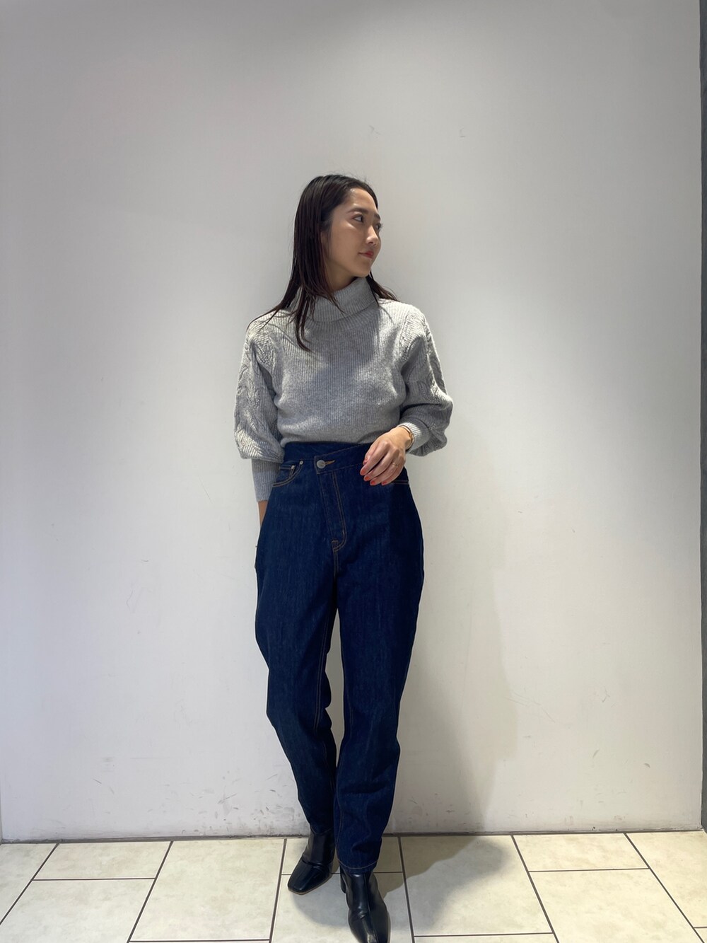 ブラック系のブーツ、ブルー系のデニムパンツ、グレー系のニット/セーターを着用したレディースの秋コーディネートの4枚目の写真