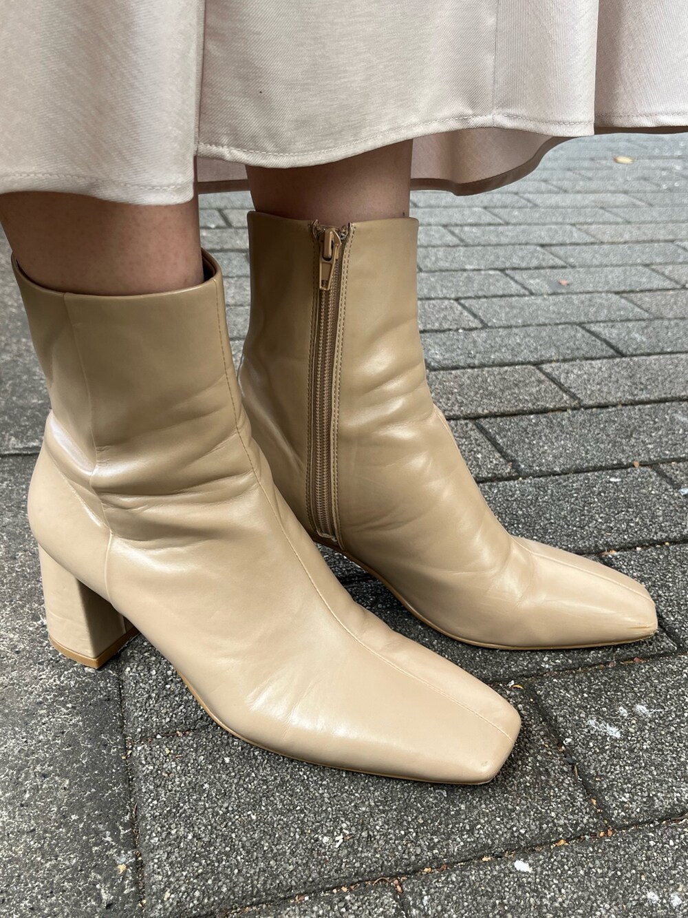 ベージュ系のニット/セーター、ベージュ系のブーツ、グレー系のスカートを着用したレディースの冬コーディネートの8枚目の写真